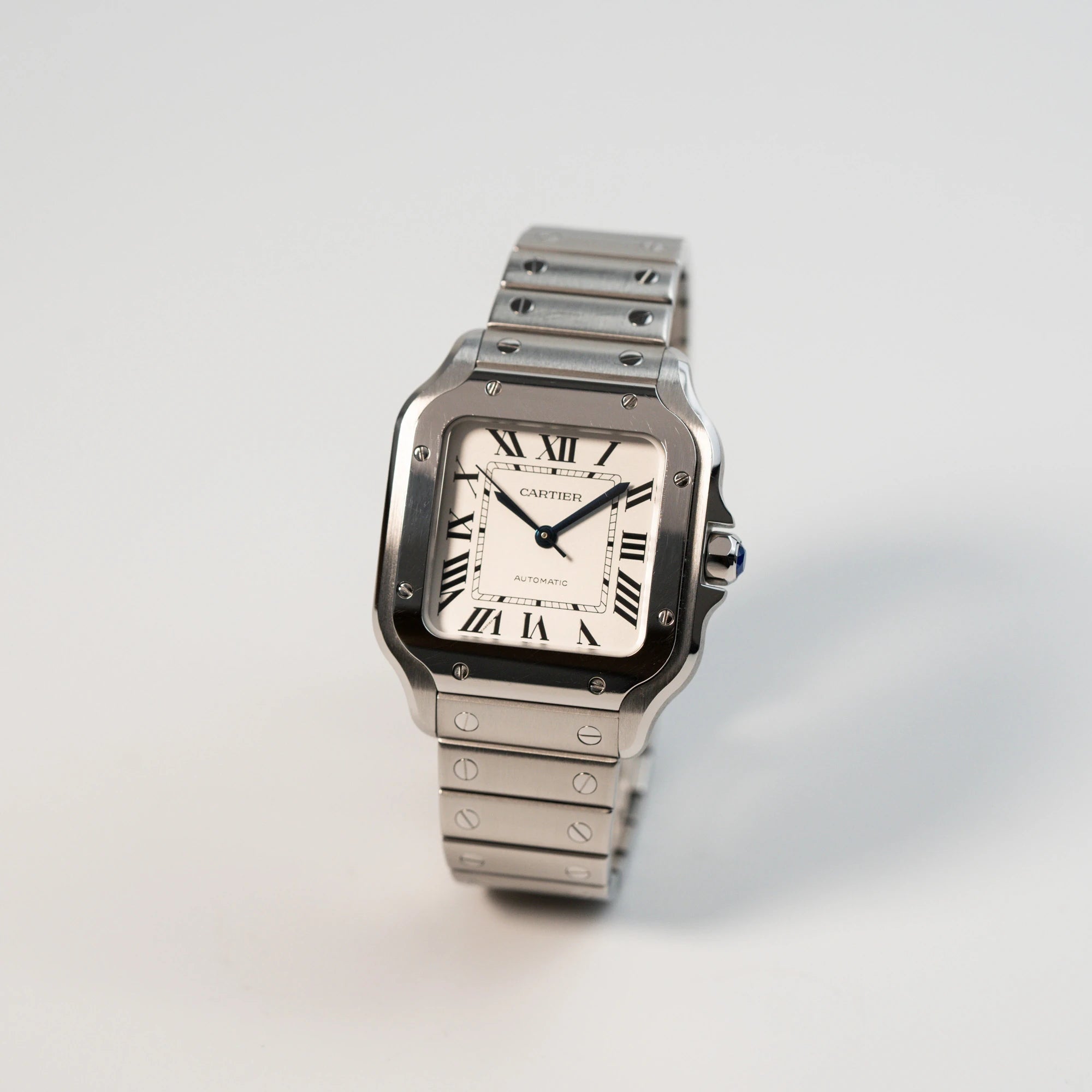 Leicht schräge Ansicht der Cartier Santos Medium mit dem klassischen weißen Zifferblatt mit römischen Indizes