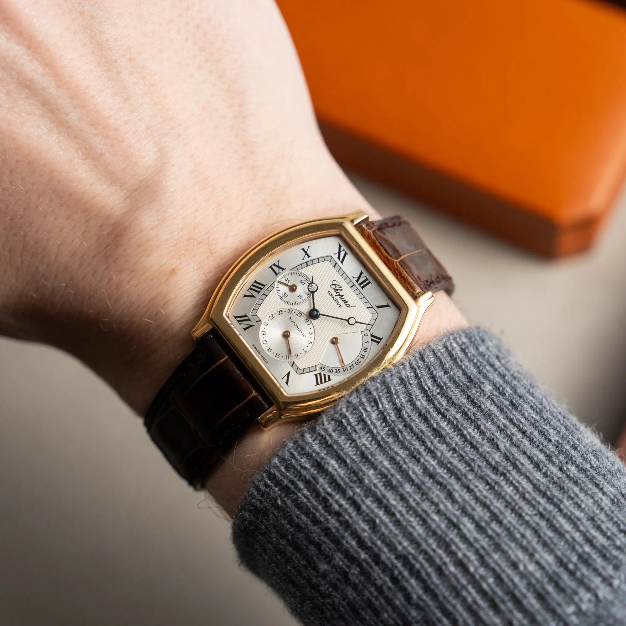 Mann präsentiert die Chopard Tonneau Powerreserve 2248 mit Gehäuse aus 18k Roségold an seinem Handgelenk in die Kamera