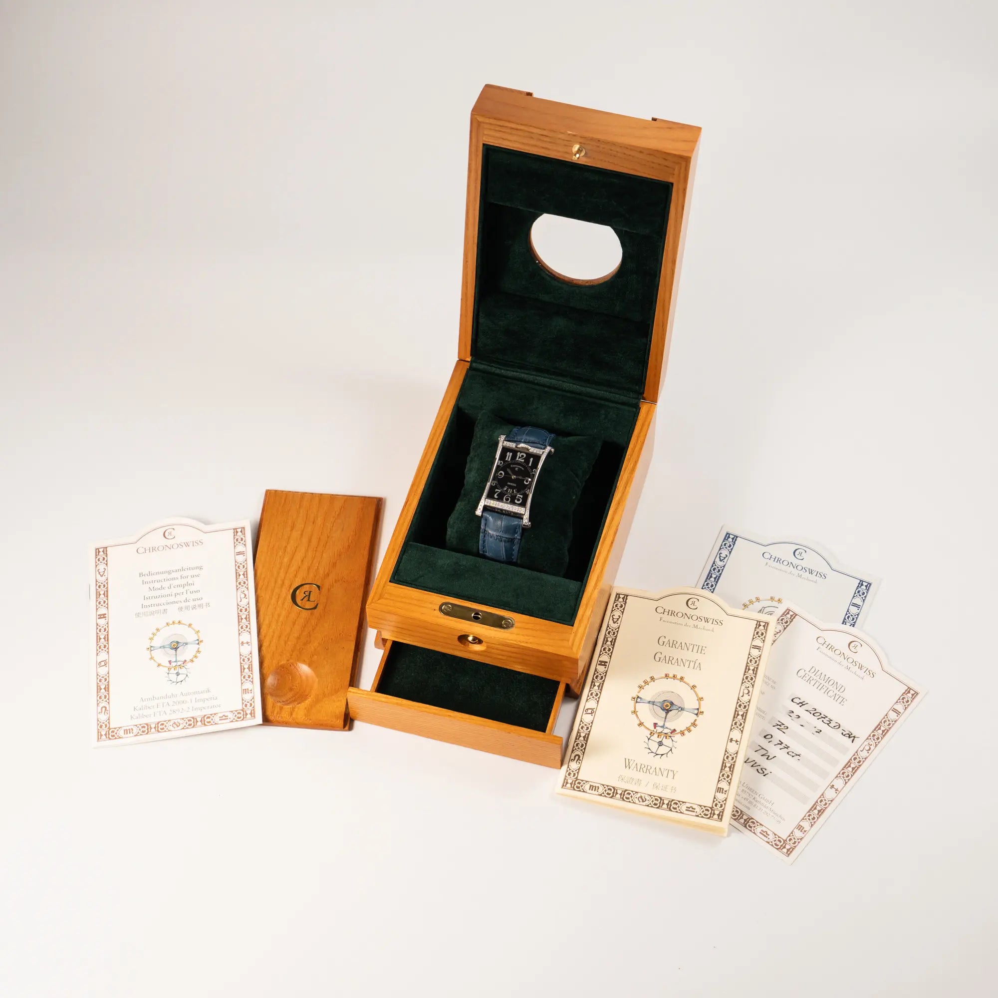 Chronoswiss Imperia Constanze mit diamantbesetzten-Stahlgehäuse mit schwarzem Zifferblatt an einem petrol-blauem Lederband zusammen mit dem Lieferumfang, bestehend aus Chronoswiss-Holz-Box, Zertifikat und Garantiekarte