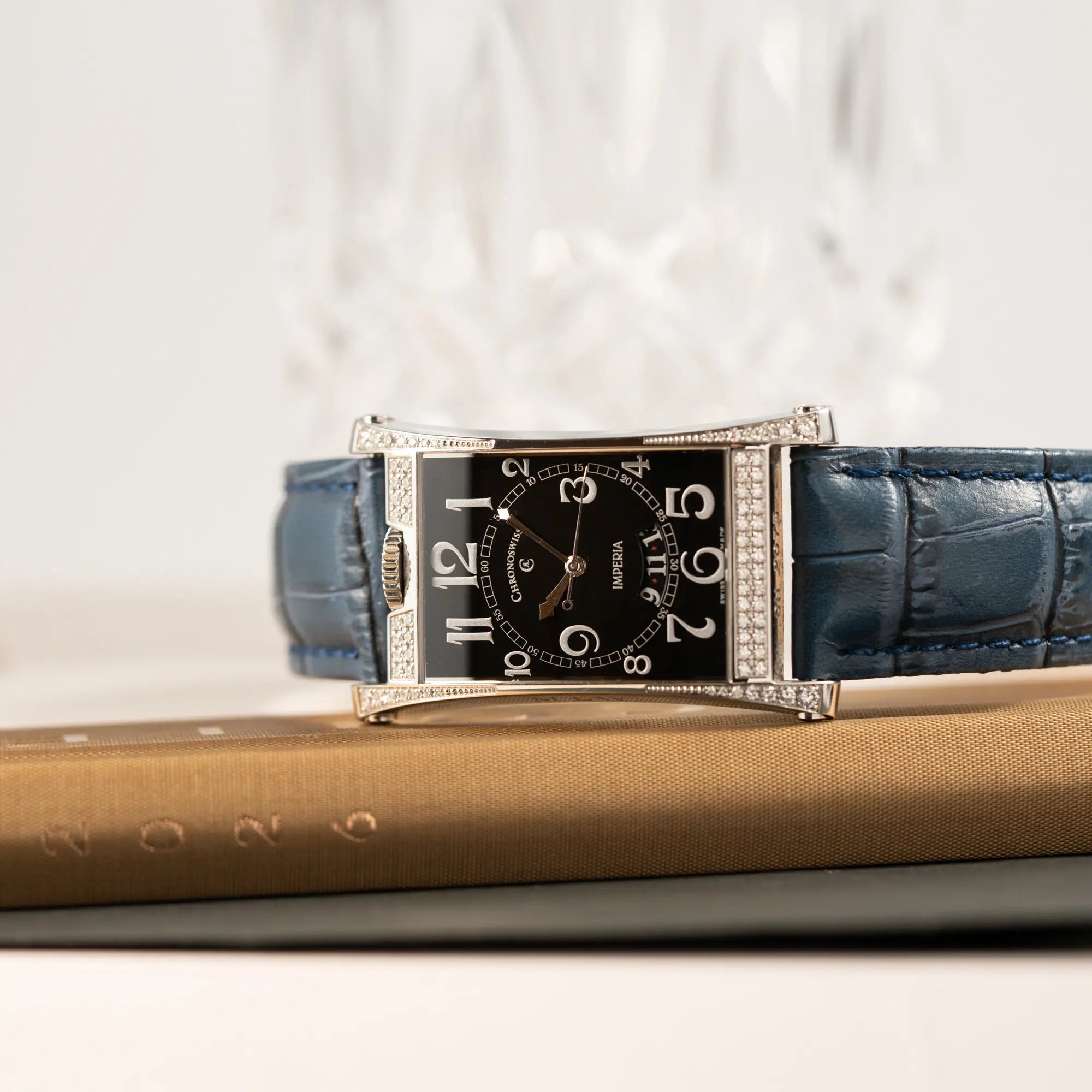 Produktfotografie als Titelbild für die Chronoswiss Imperia Constanze mit diamantbesetzten-Stahlgehäuse mit schwarzem Zifferblatt an einem petrol-blauem Lederband