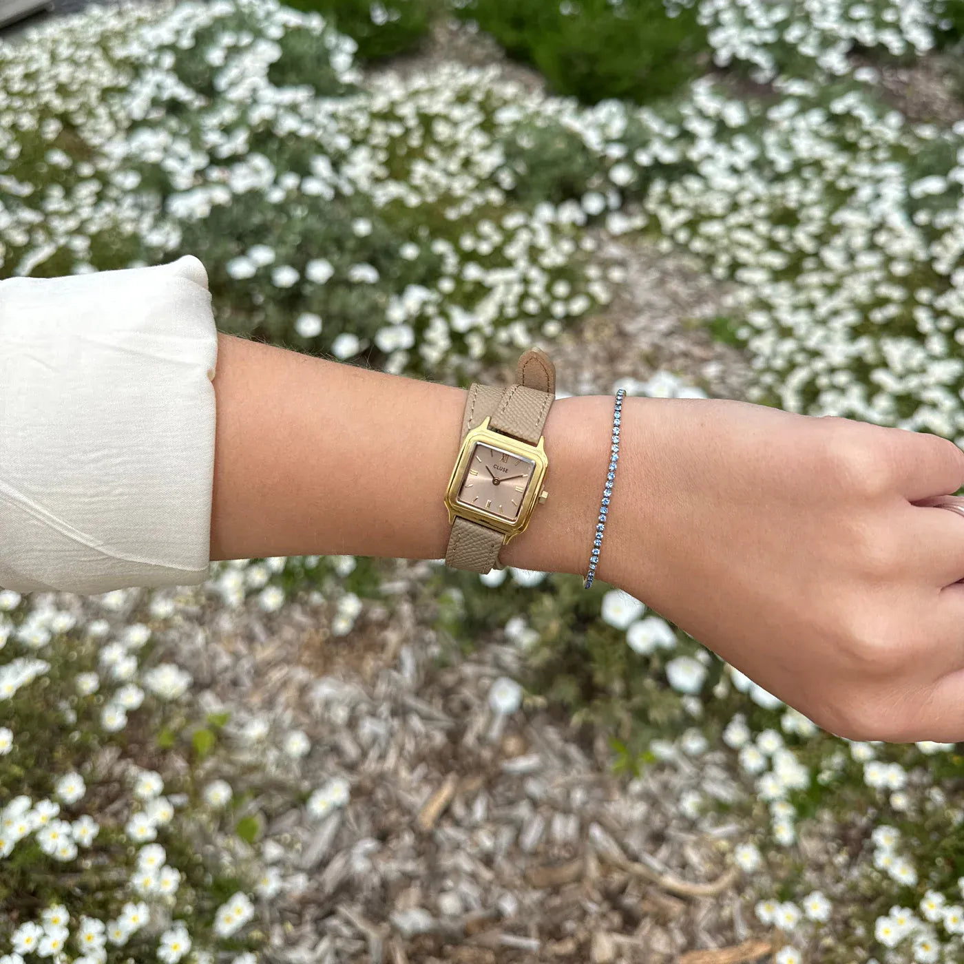 Wristshot mit der der goldfarbenen Cluse Gracieuse Petite Damenuhr mit rechteckigem Gehäuse und beigem/bronze-farbenem Zifferblatt an einem Doppel-Armband aus Leder im gleichen Farbton wie das Zifferblatt