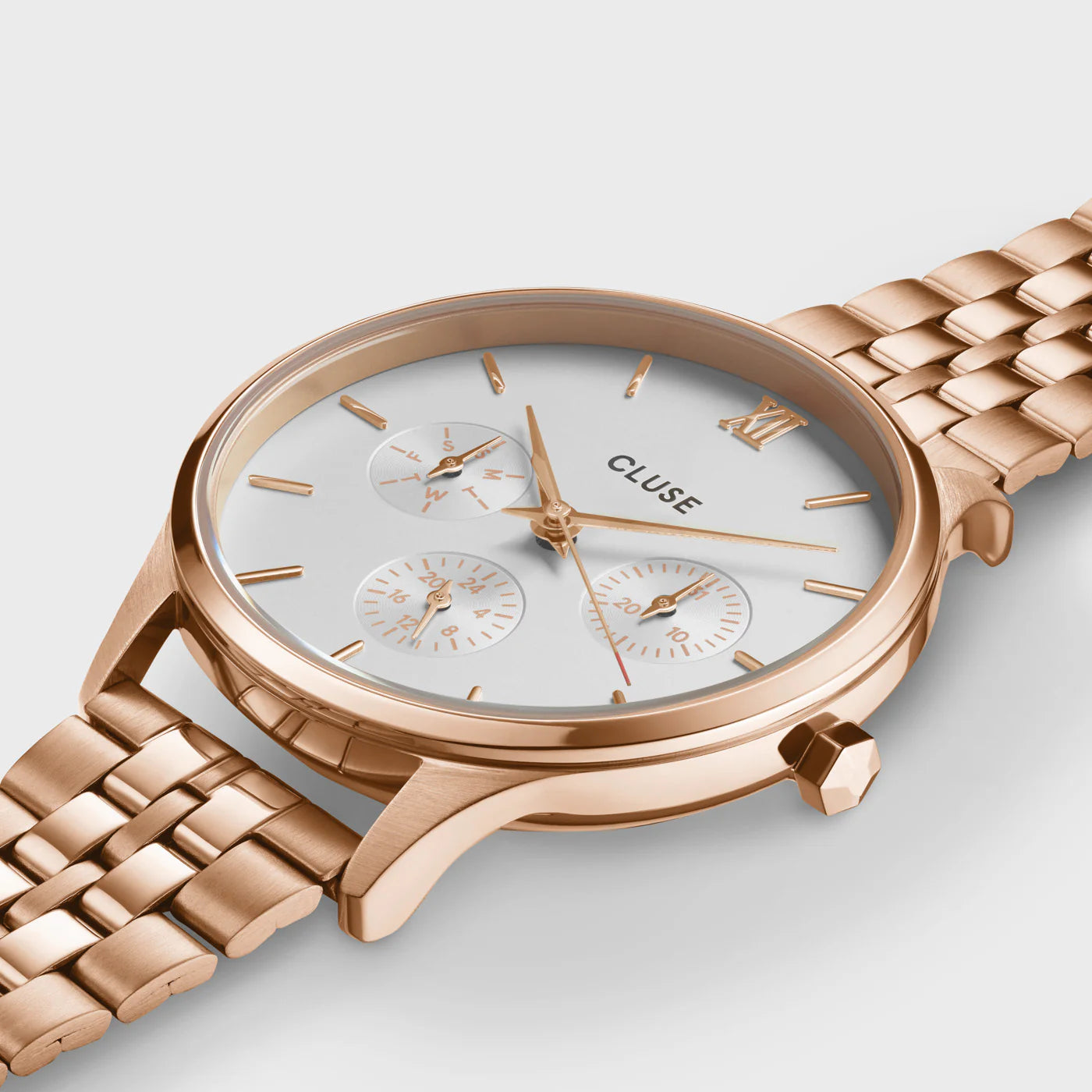 Leicht schräge Ansicht der Cluse Stahl-Uhr "Minuit Multifunction" im Rosègold-Look mit weißem Zifferblatt und drei Sub-Dials zur Wochentags-, Datums-Anzeige und 24 Stunden-Zähler
