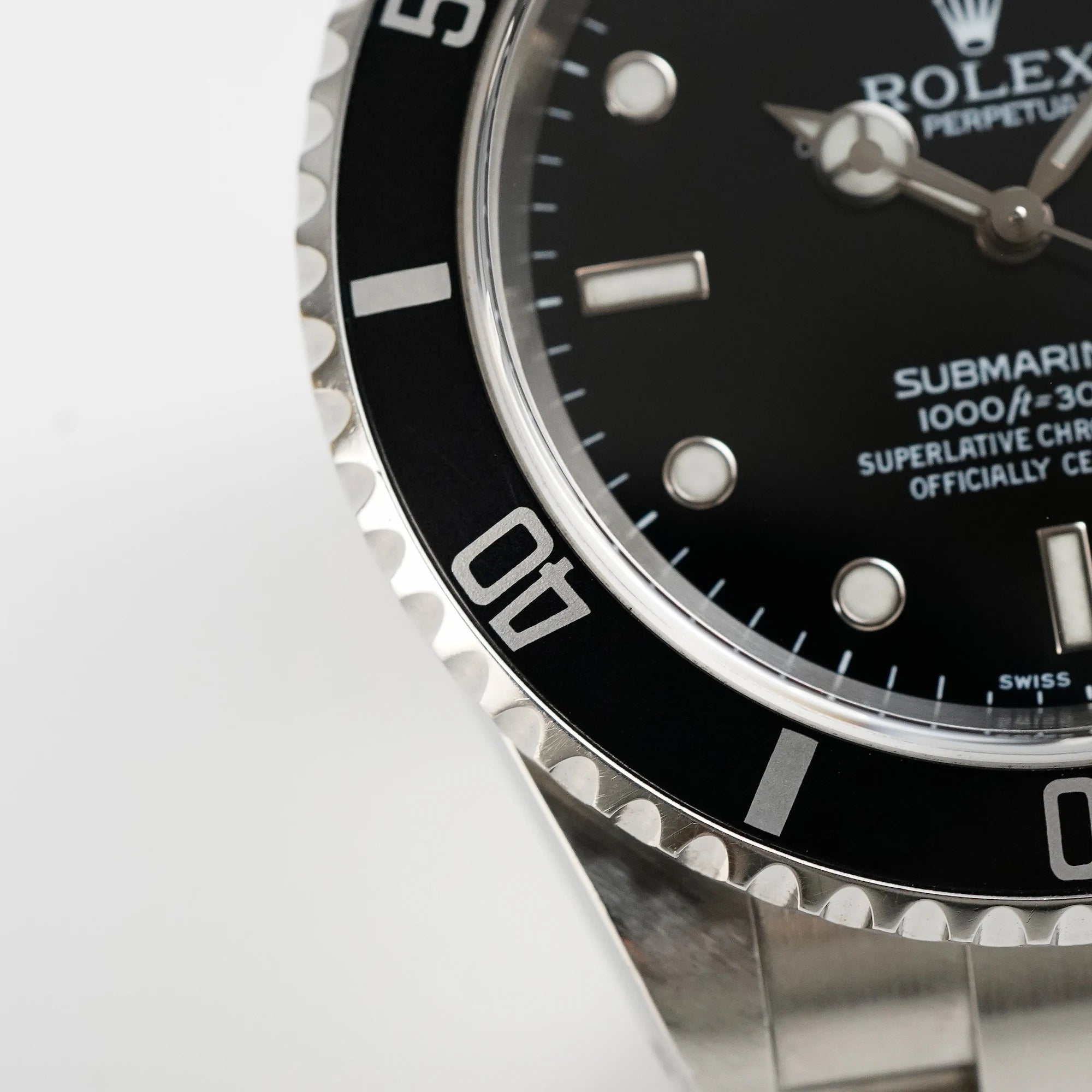 Makroaufnahme der Lünette mit Flat-Four der Rolex Submariner Date in schwarz, Referenz 16610