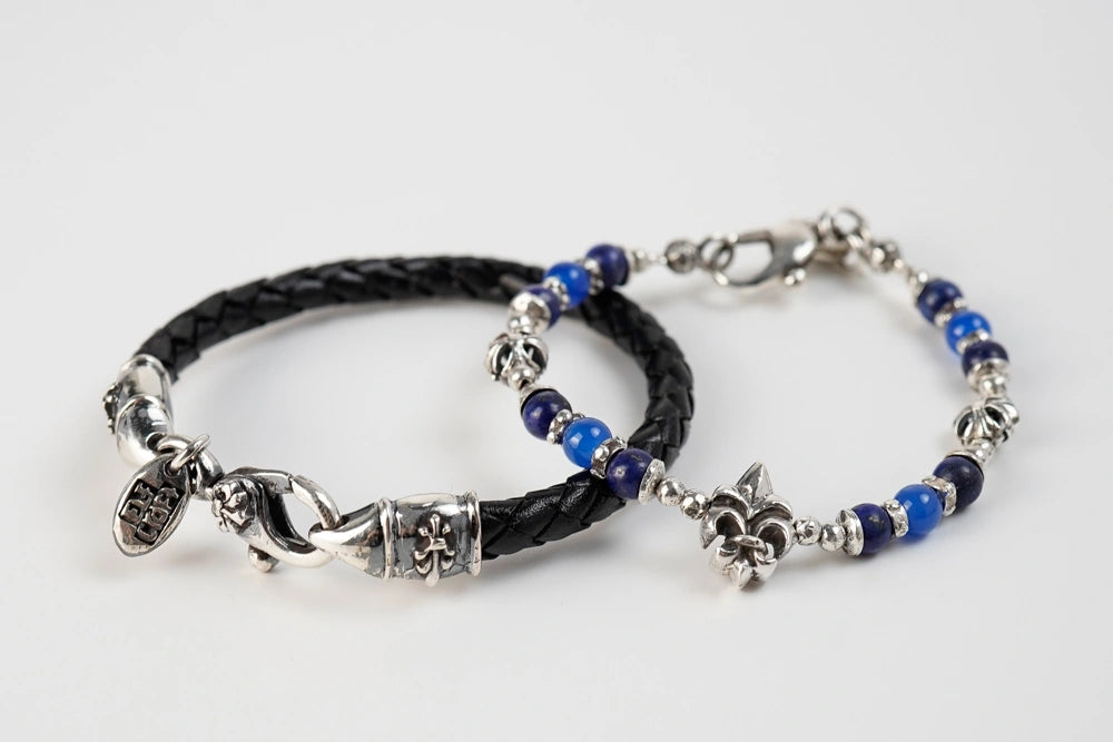 ein Armband aus schwarzem Leder und Silber und ein Armband aus Silber mit blauen Perlen