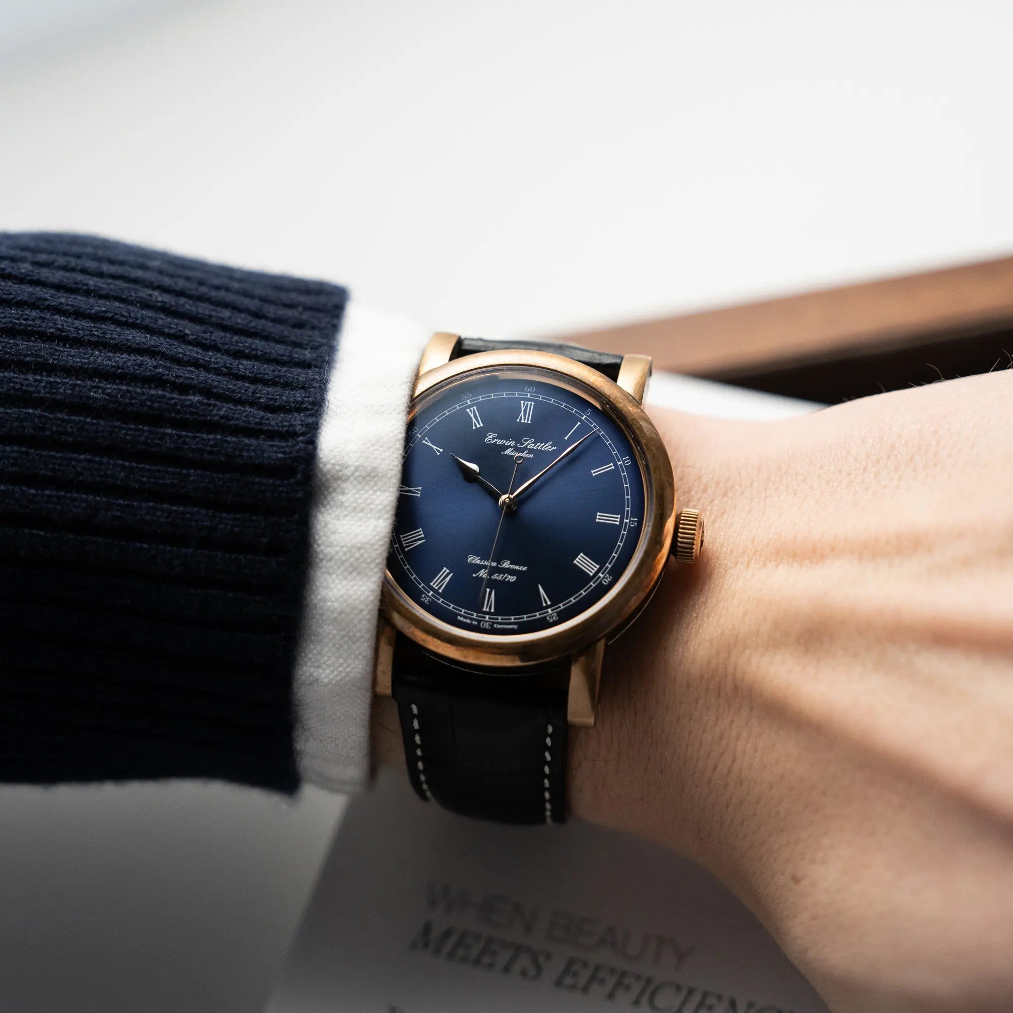 Mann trägt die limitierte Erwin Sattler Classica Armbanduhr in einem Bronze-Gehäuse mit blauem Zifferblatt an seinem Handgelenk für einen Wristshot