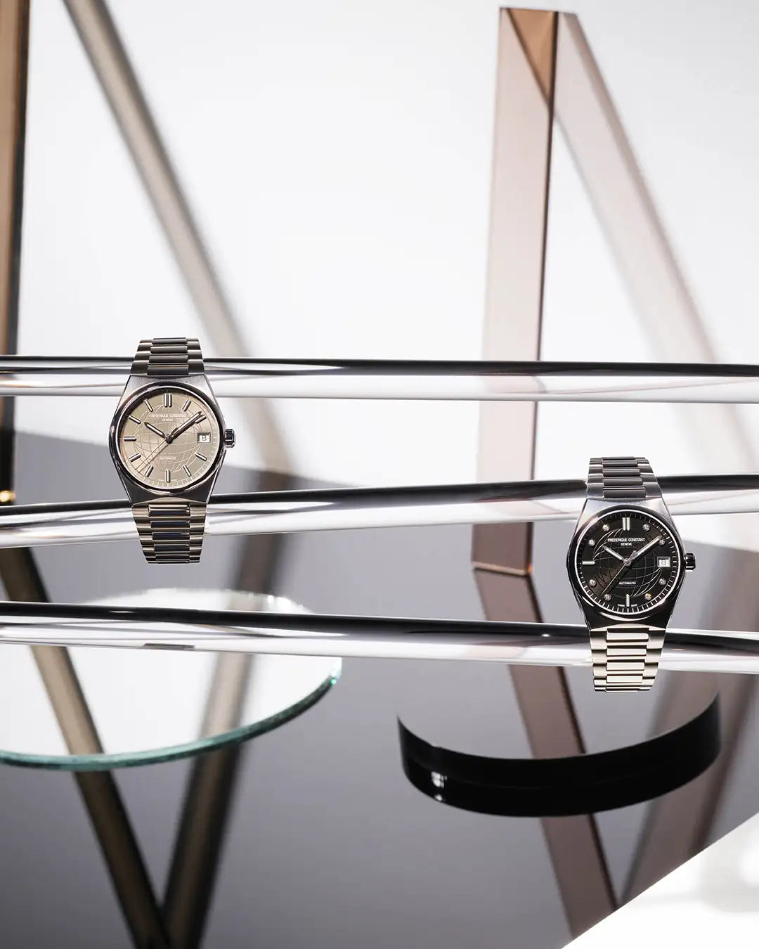 Künstlerisches Produktfoto mit zwei Armbanduhren "Highlife Ladies Automatic" von Frederique Constant, die auf transparenten Stangen präsentiert wird