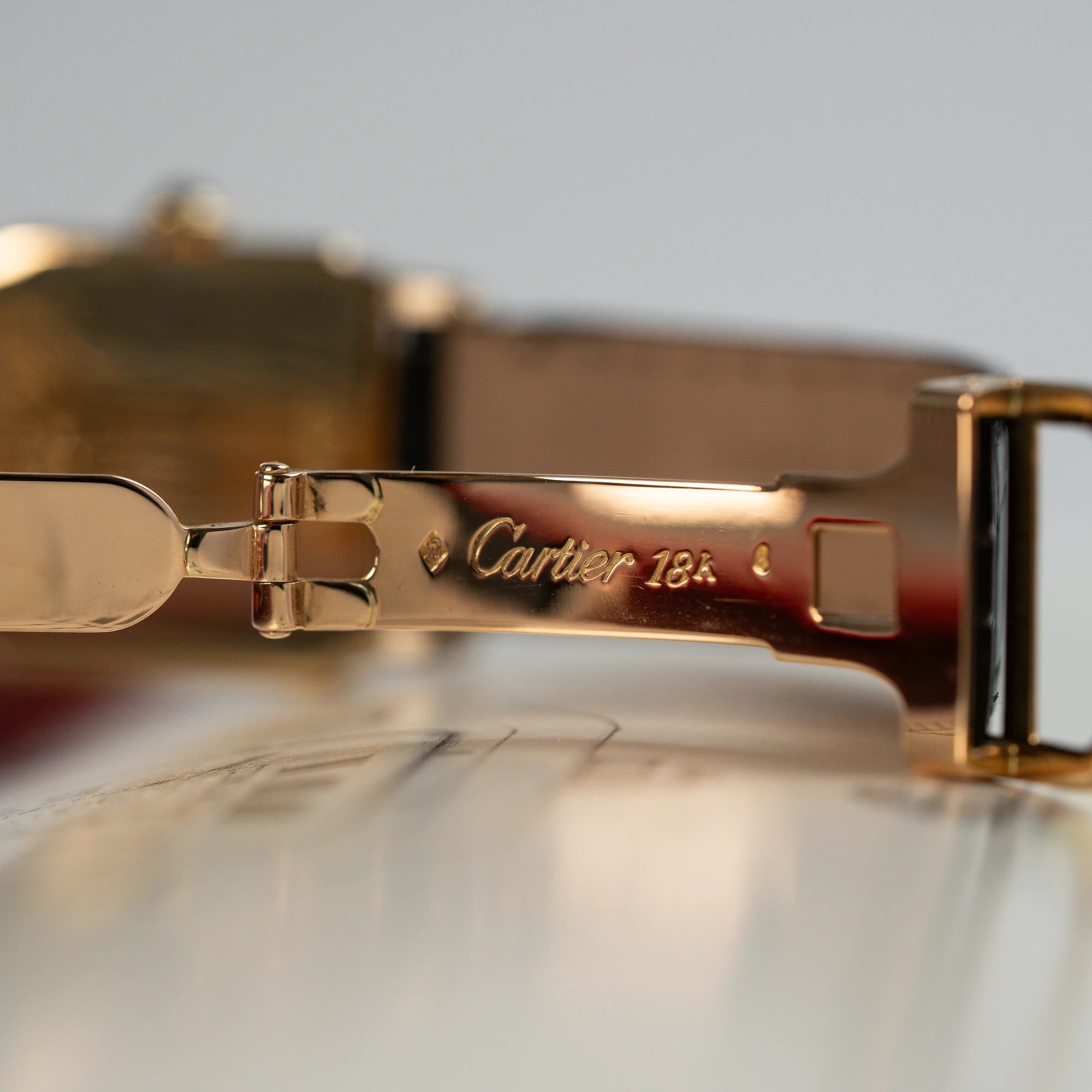 Detailaufnahme der goldenen Faltschließe aus 18 Karat für die Cartier Santos Dumont "Deux Ors"