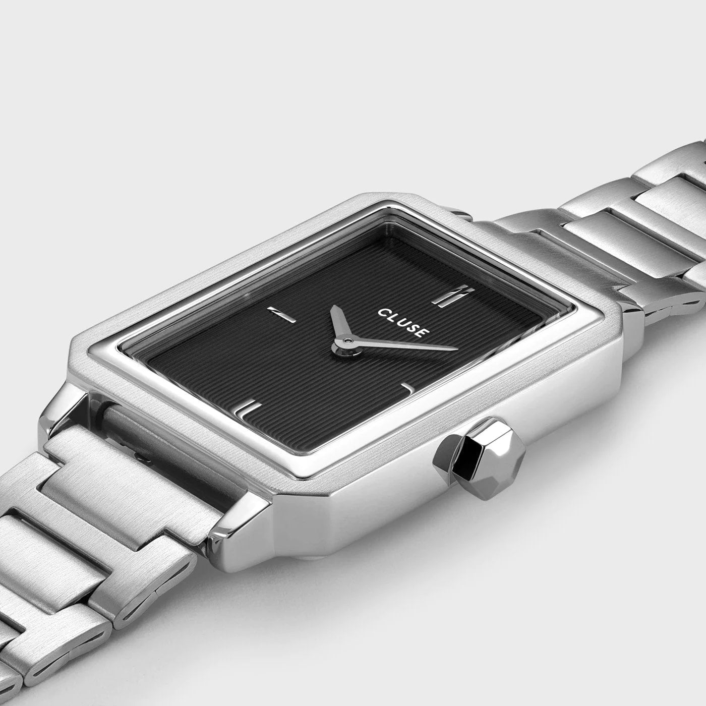 Detailaufnahme der Cluse "Fluette" Stahl-Uhr mit schwarzem, gestreiften Zifferblatt mit silberfarbenem Gehäuse mit Edelstahl-Armband