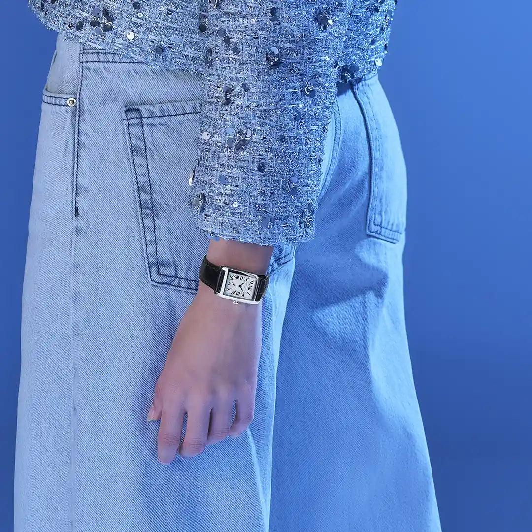 Produkfoto mit de Frederique Constant Damenuhr FC-235S2C6 aus der Classic-Kollektion mit einem rechteckigen Uhrengehäuse und einem silbernen Zifferblatt mit römischen Ziffern und der kleinen Sekunde auf 6 Uhr, während eine Frau die Uhr am Handgelenk trägt