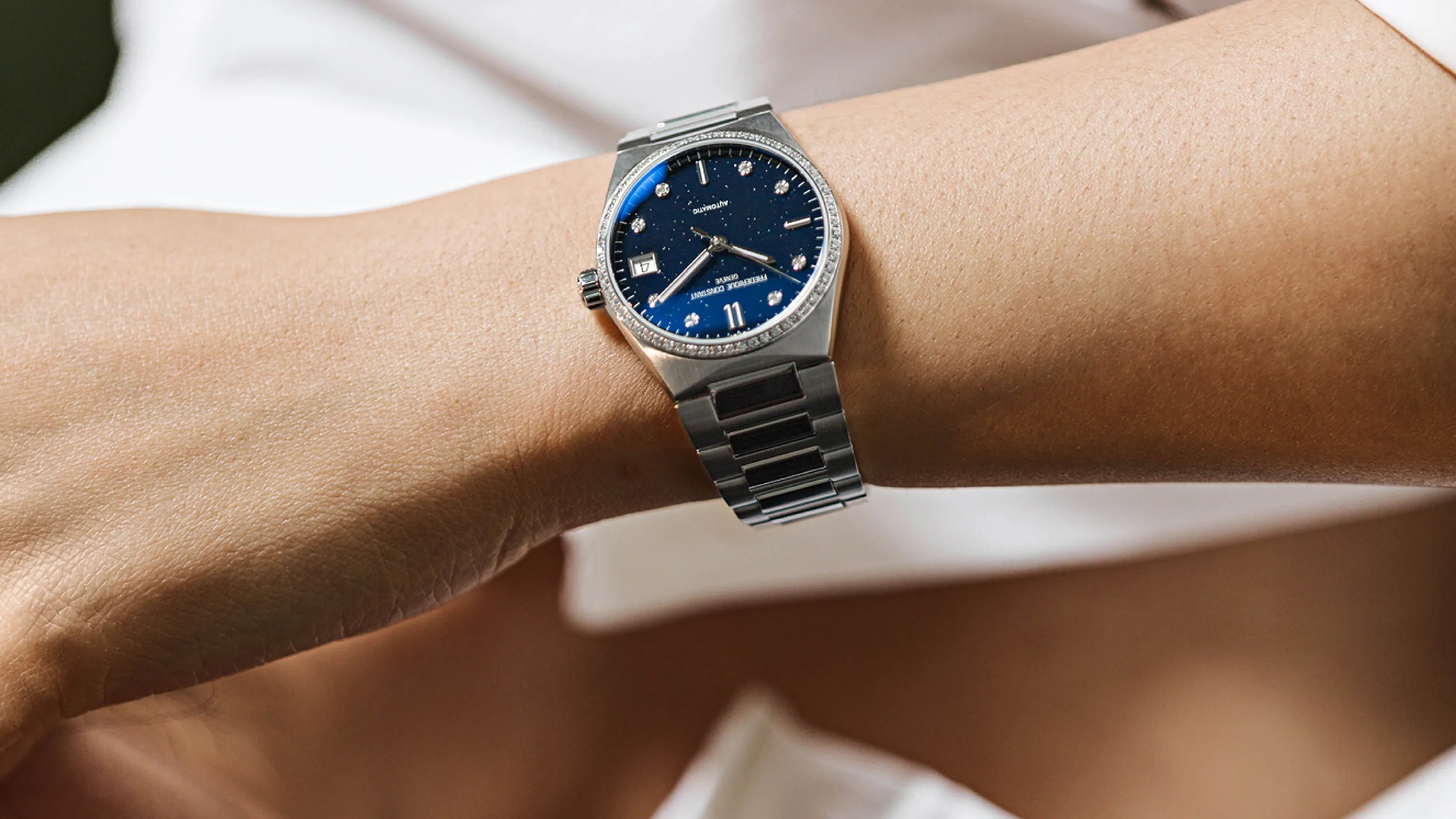 Frederique Constant Damenuhr Highlife in Edelstahl blaues Blatt mit Diamant-Luenette am Handgelenk einer Frau