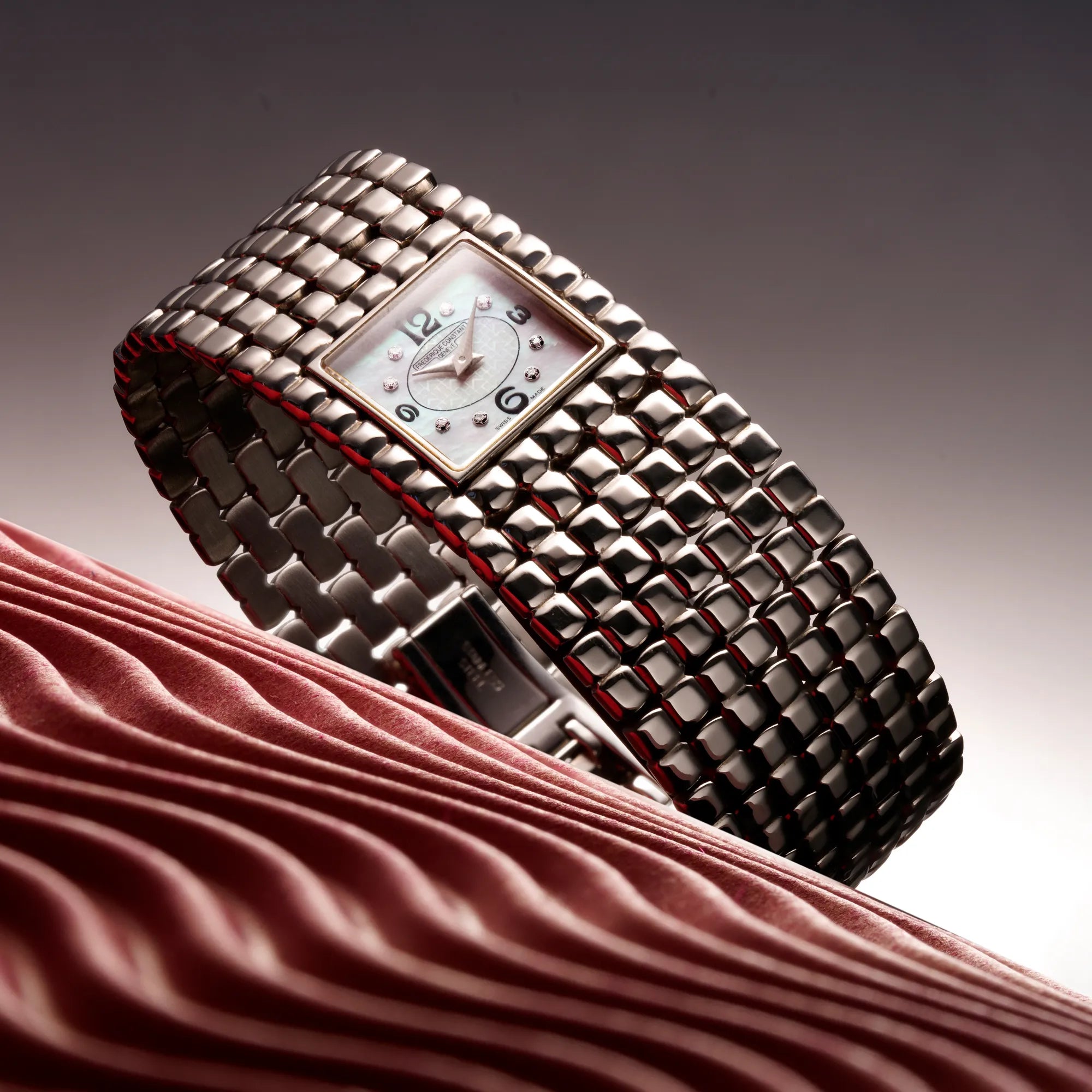 Produktfotografie der ursprünglichen Manchette Armbanduhr von Frederique Constant mit einem verzierten, rechteckigen Perlmutt-Zifferblatt, die insgesamt mehr einem Armband ähnelt, welche seit über 2o Jahren nicht mehr produziert wird