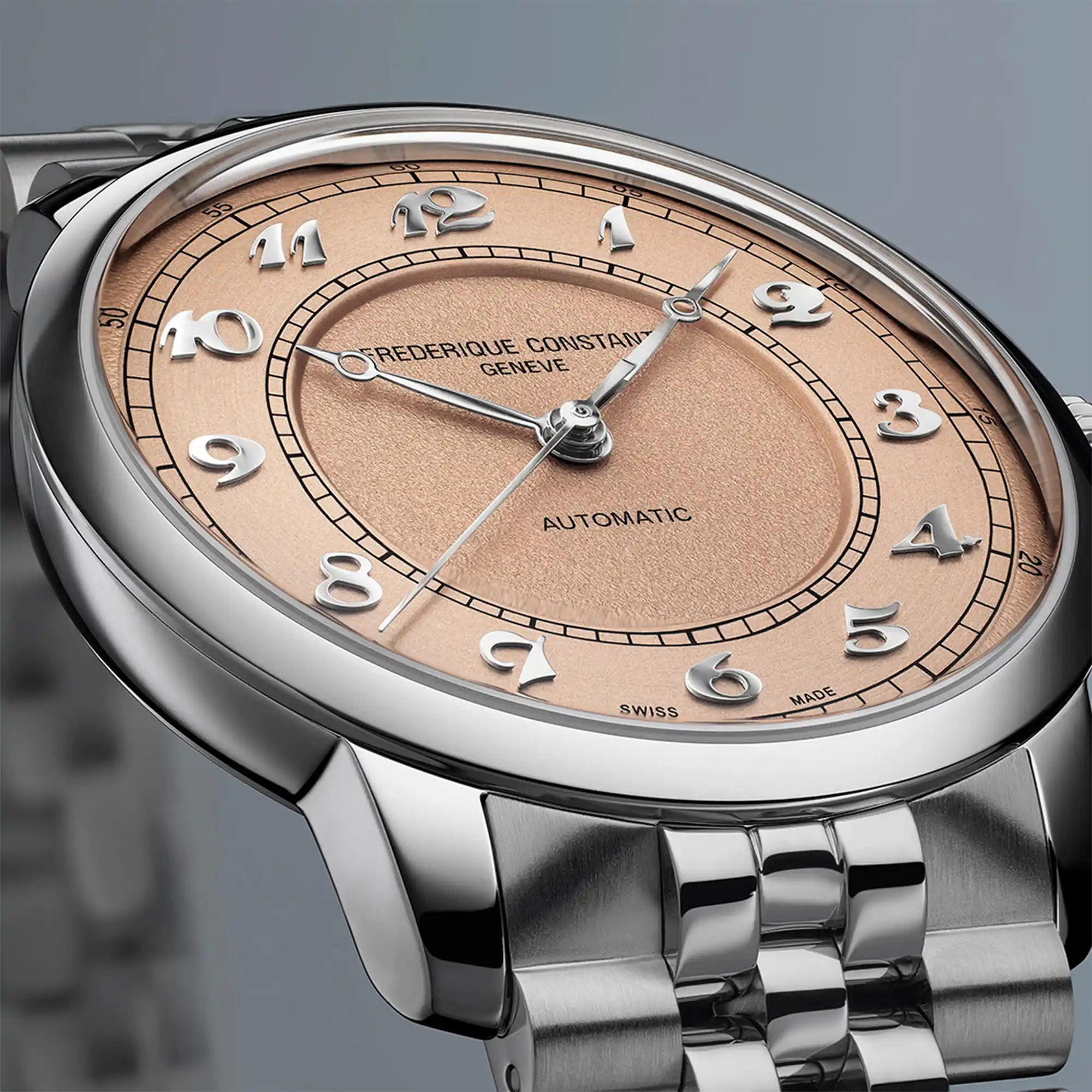 Detailaufnahme des Uhrenkopfes der Frederique Constant "Classics Premiere" Armbanduhr FC-301SALB6B mit lachsrosa-farbenen Zifferblatt mit zwei verschiedenen Oberflächenstrukturen und arabischen Ziffern im klassischen Stil
