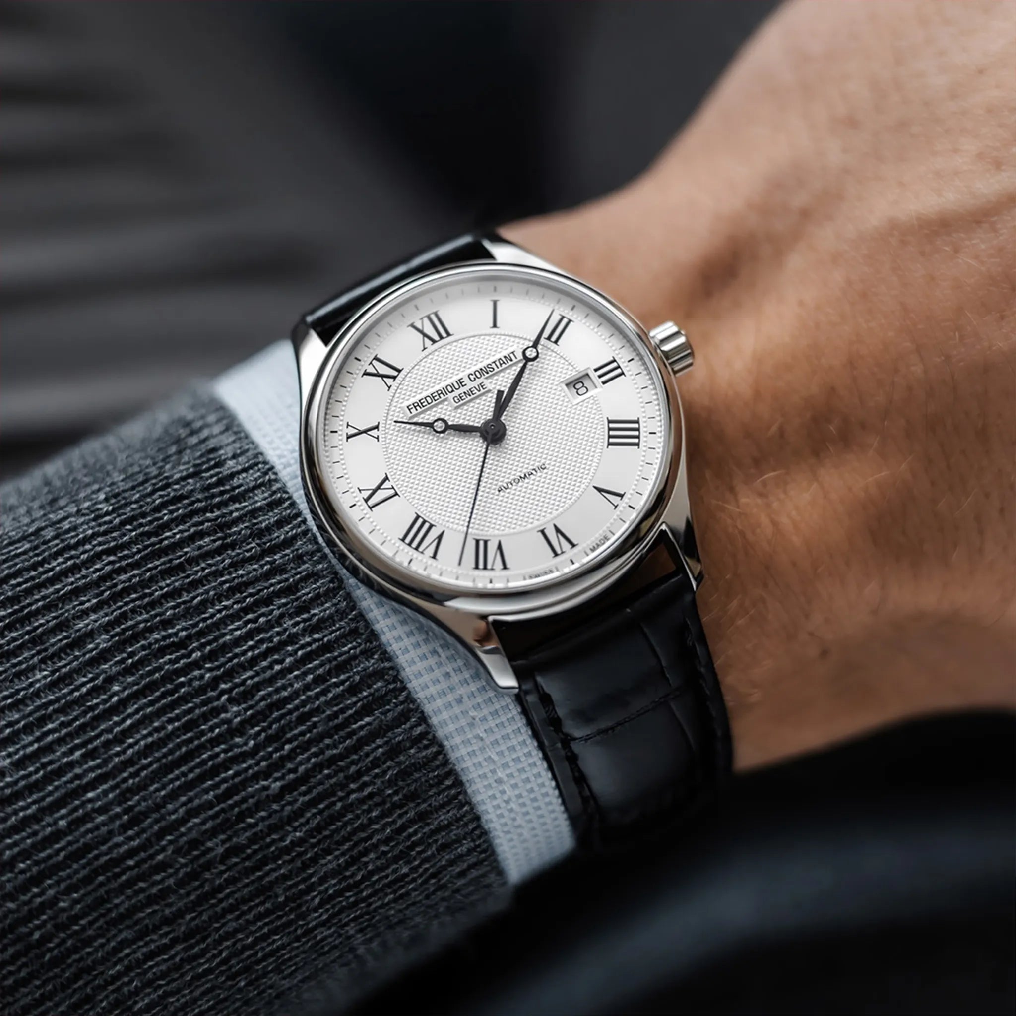 Mann trägt die Frederique Constant Classics Automatic FC-303MC5B6 mit silberfarbenen Zifferblatt und römischen Indizes an seinem Handgelenk