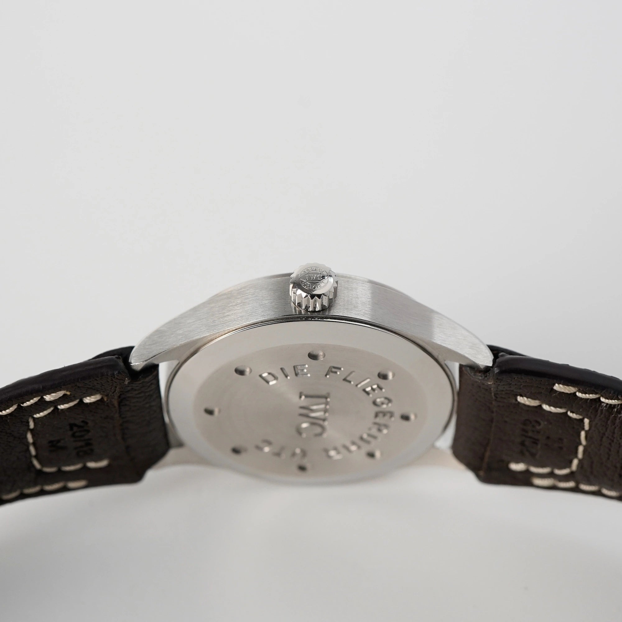 Blick auf die Krone und den Gehäuseboden IWC Schaffhausen Pilot Fliegeruhr UTC Spitfire mit der Referenz IW3251 mit braunem Lederband