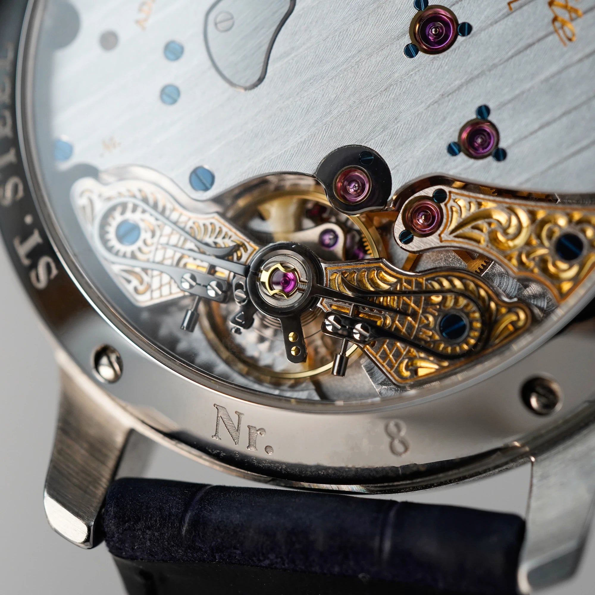 Makroaufnahme des gläsernen Gehäusebodens der Glashütte Original Panoreserve Uhr mit Fokus auf dem wunderschönen, durch Gravuren veredelten Uhrwerks
