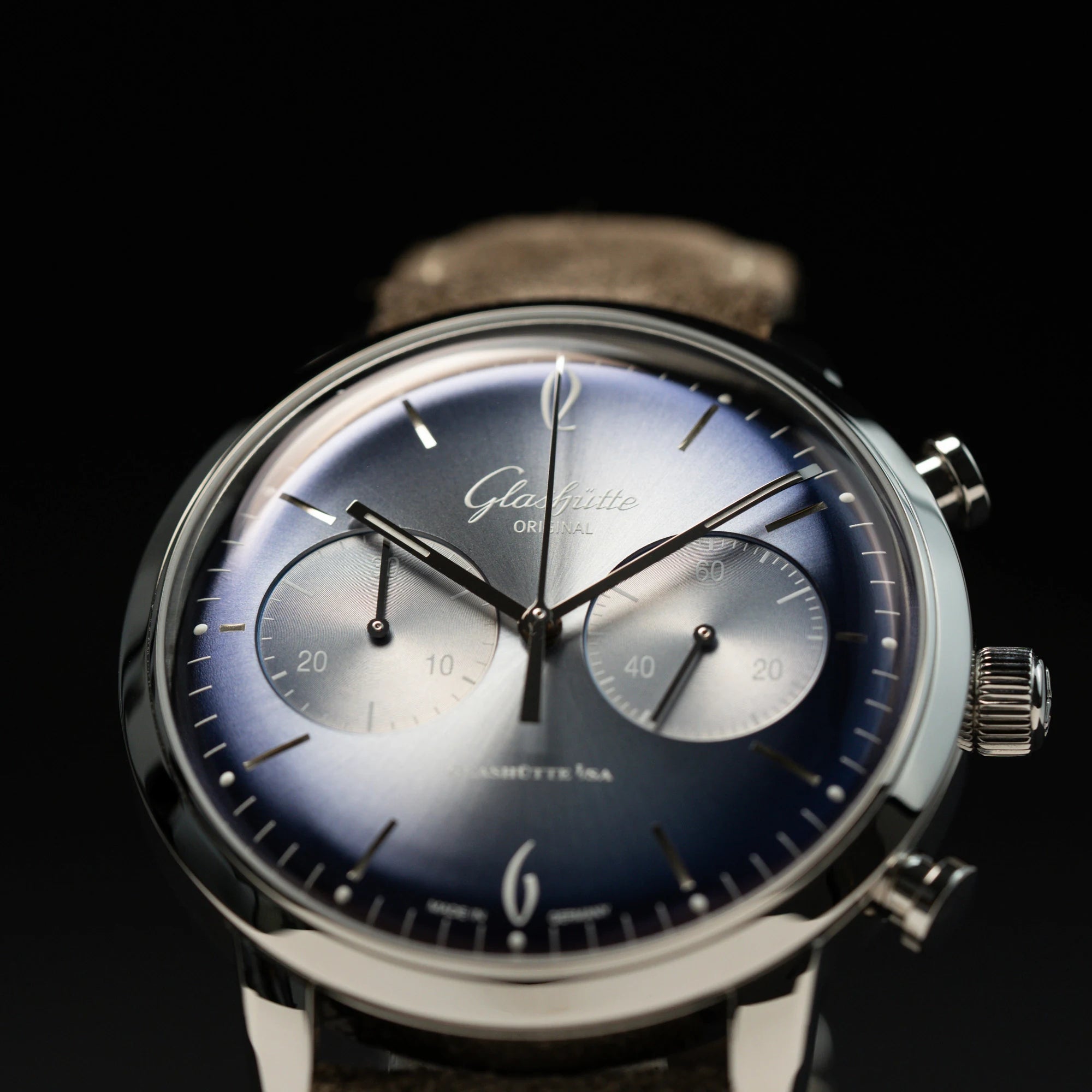 Detailaufnahme des blauen Zifferblatts mit Sonnenschliff des Glashütte Original Sixties Chronograph mit komplett schwarzem Hintergrund