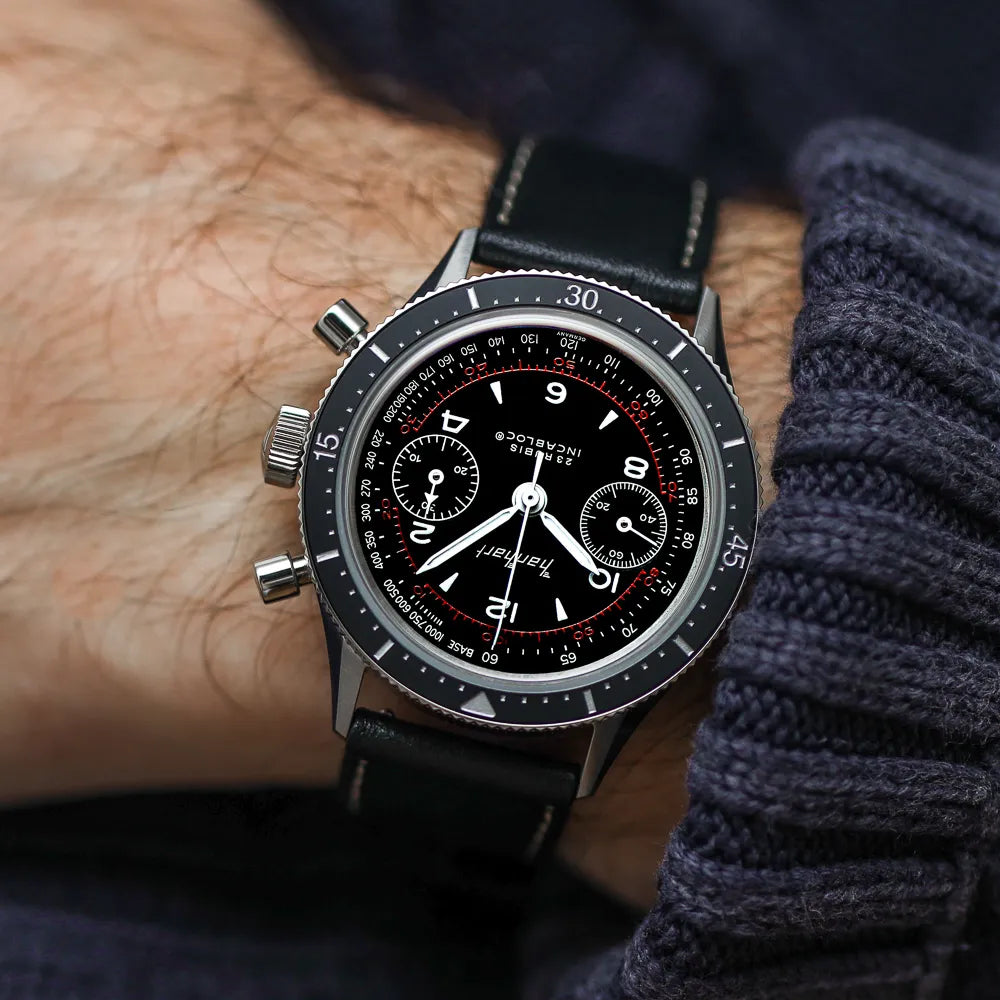 Mann trägt den Hanhart 415 ES Pure Chronographen in Edelstahl mit weißen und roten Details am Lederband an seinem Handgelenk