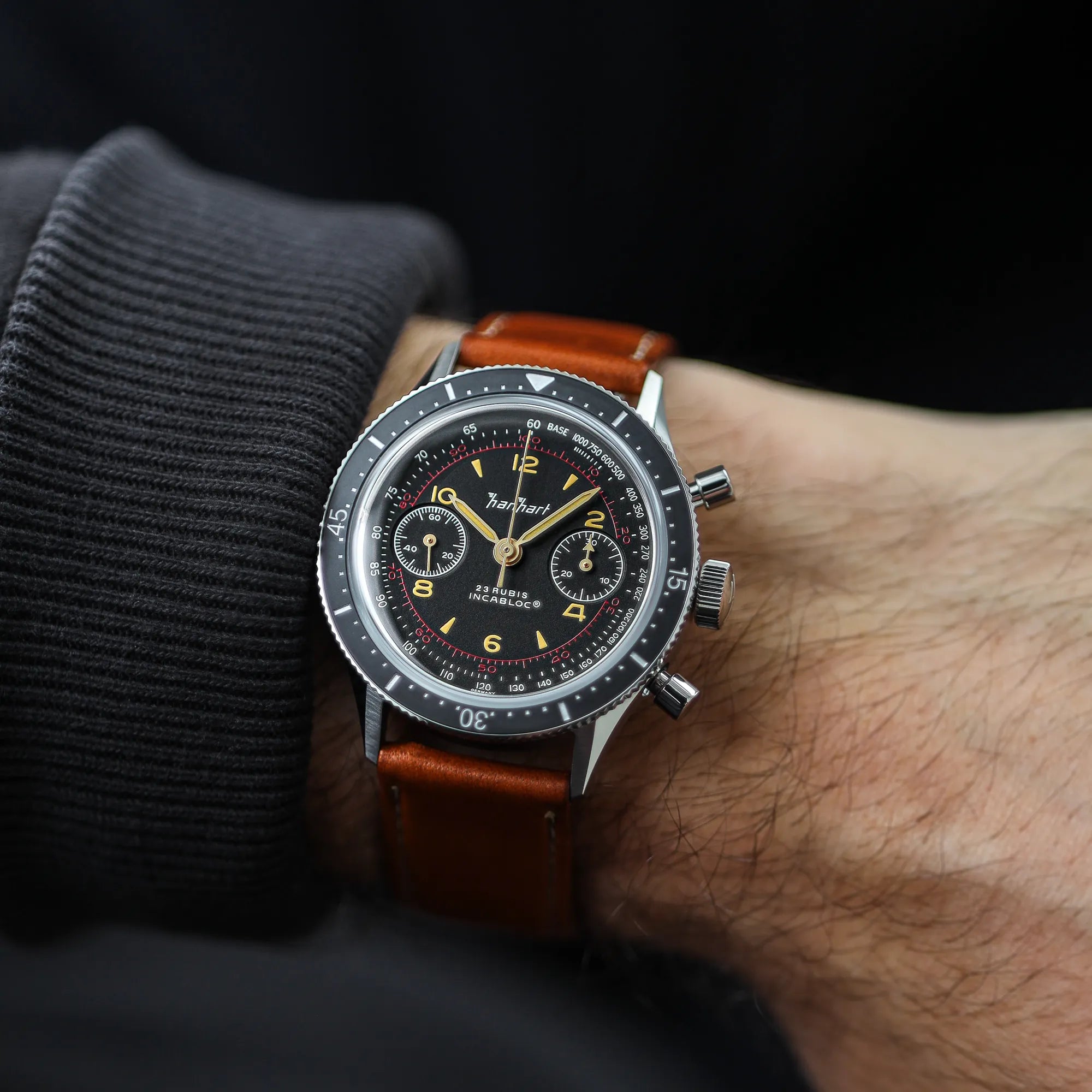 Mann trägt den klassischen Hanhart Chronographs "415 ES" an einem braunen Lederband an seinem Handgelenk