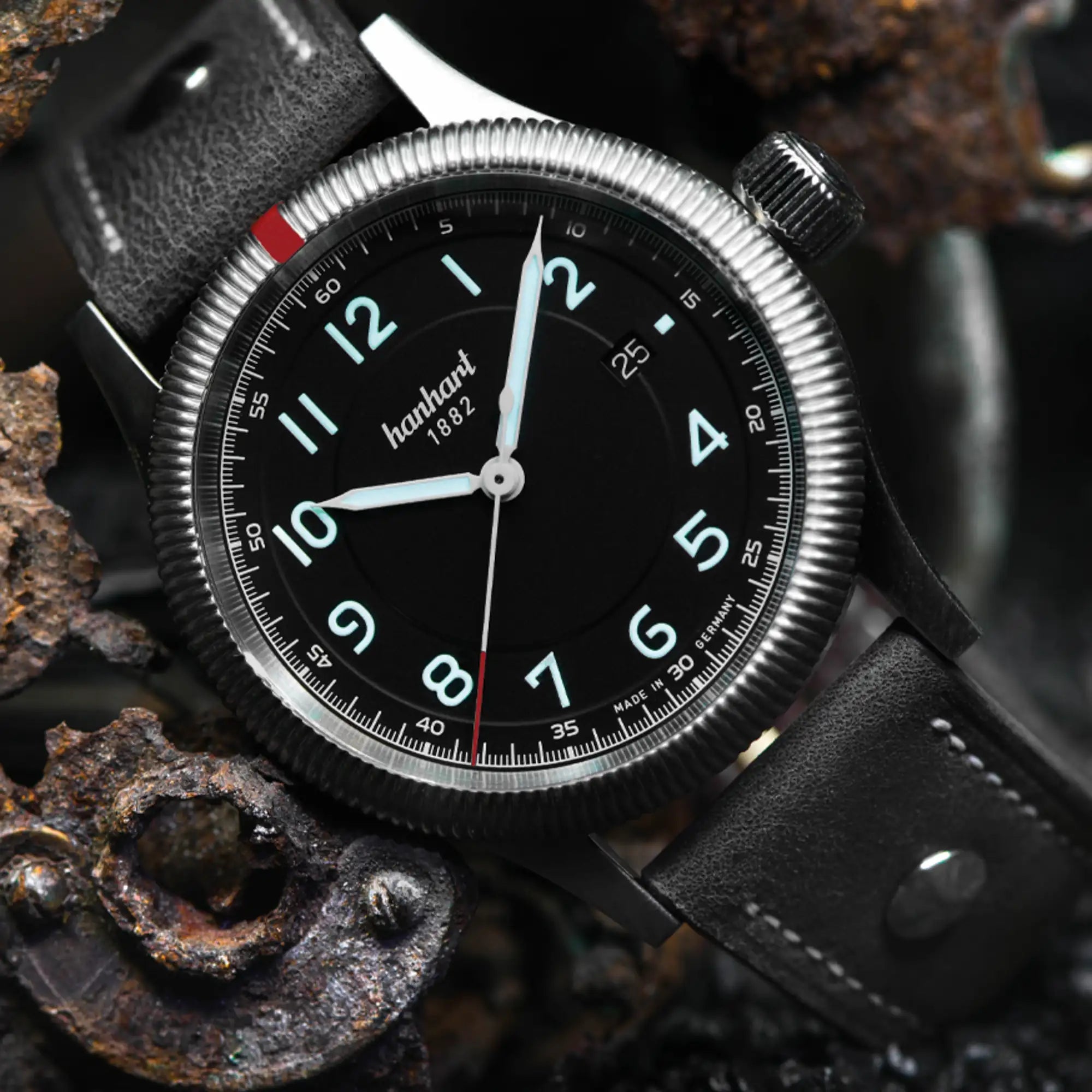 Produktfotografie der klassischen Dreizeiger-Armbanduhr Pioneer One mit schwarzem Zifferblatt von Hanhart an einem schwarzen Lederband