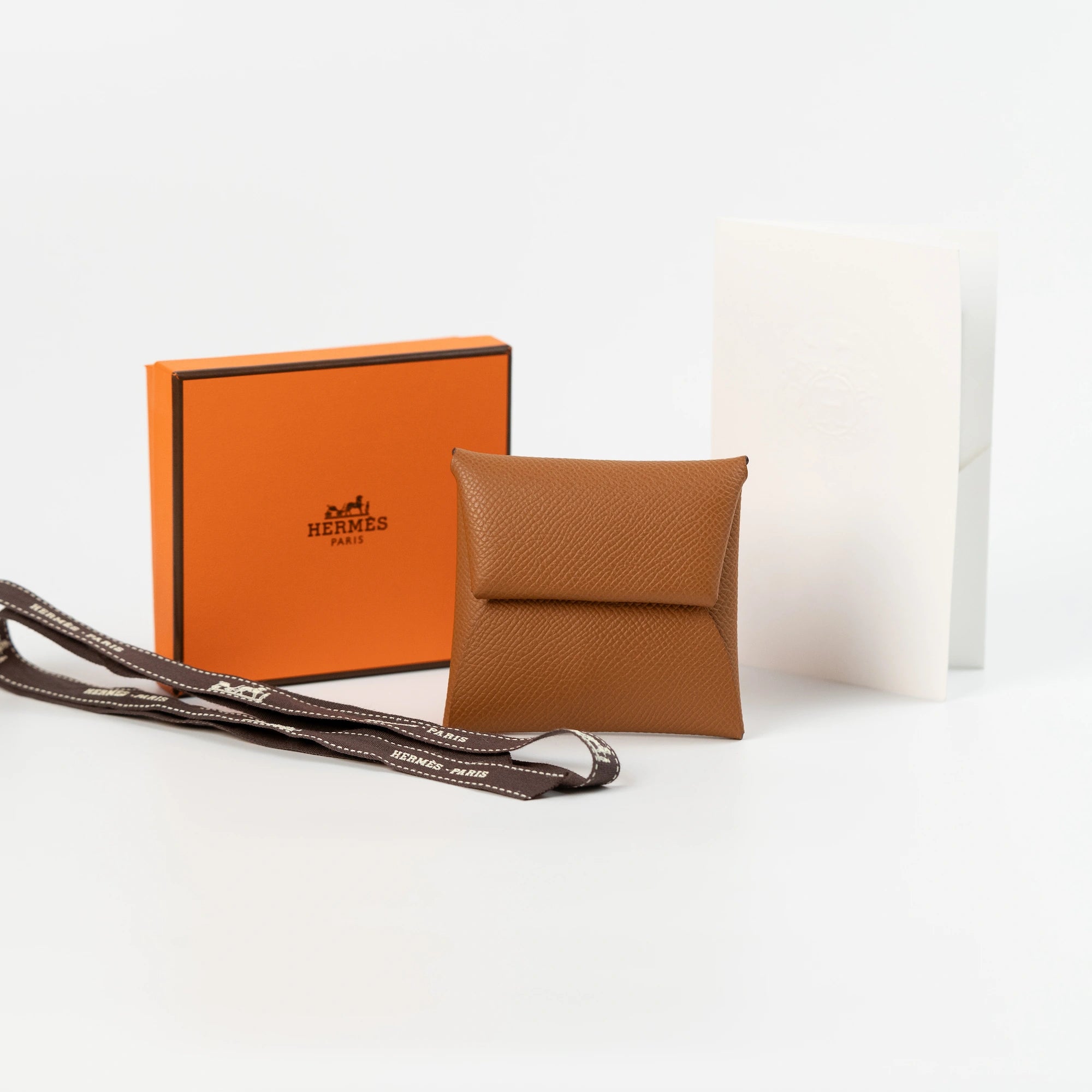 Hermès "Bastia" Portmonnaie in einem cognacfarbenen Leder zusammen mit dem Lieferumfang, bestehend aus orangener Hermes Schachtel und Papieren