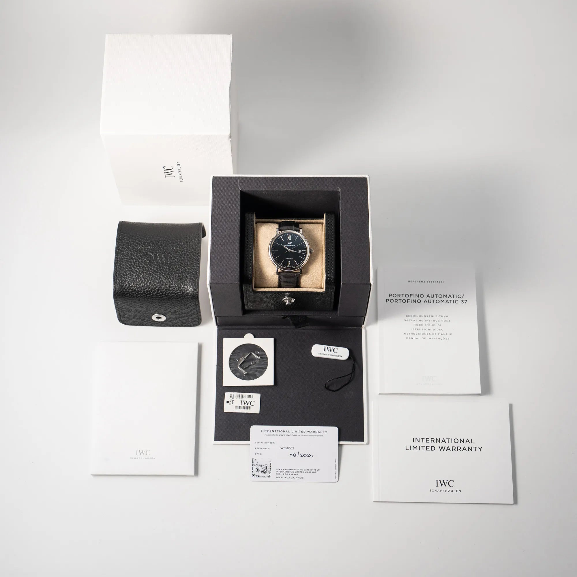 Lieferumfang zu der IWC Portofino 40 Automatik Armbanduhr mit schwarzem Zifferblatt am schwarzen Lederband bestehend aus Box, mit Umkarton, Hangtag, Garantiekarte, Bedienungsanleitung und zusätzlicher Dornschliesse