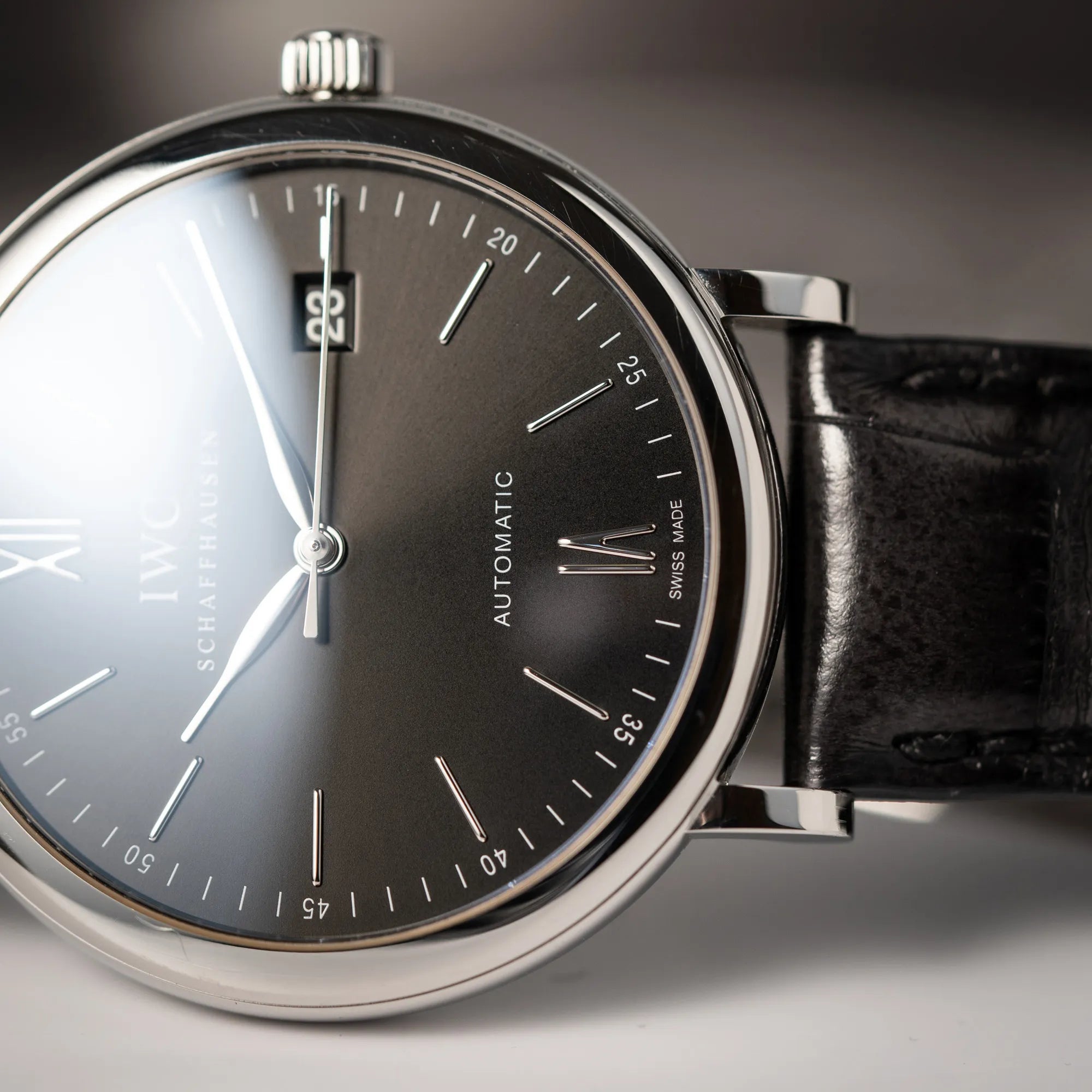 IWC Portofino 40 Automatik Armbanduhr mit schwarzem Zifferblatt am schwarzen Lederband mit Fokus auf der römischen 6