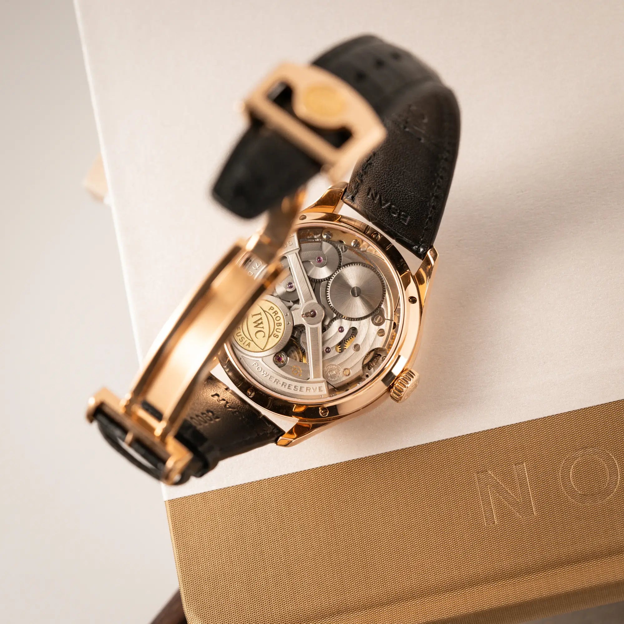 Produktfotografie des IWC Perpetual Calenders IW502122 in 44m Rosegold zeigt das mechanische Uhrwerk durch den Glasboden