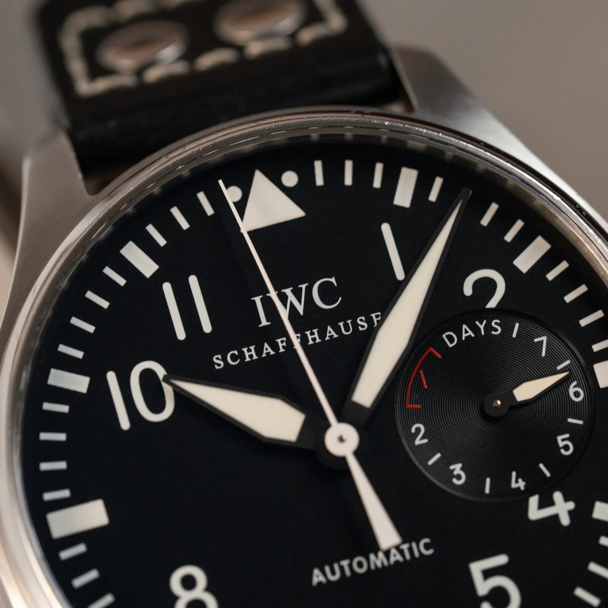 Detailaufnahme der IWC Big Pilot 46 Armbanduhr der Referenz IW500401 mit schwarzem Zifferblatt und der Power-Reserve-Anzeige bei 3 Uhr mit Fokus auf dem oberen Teil der Lünette