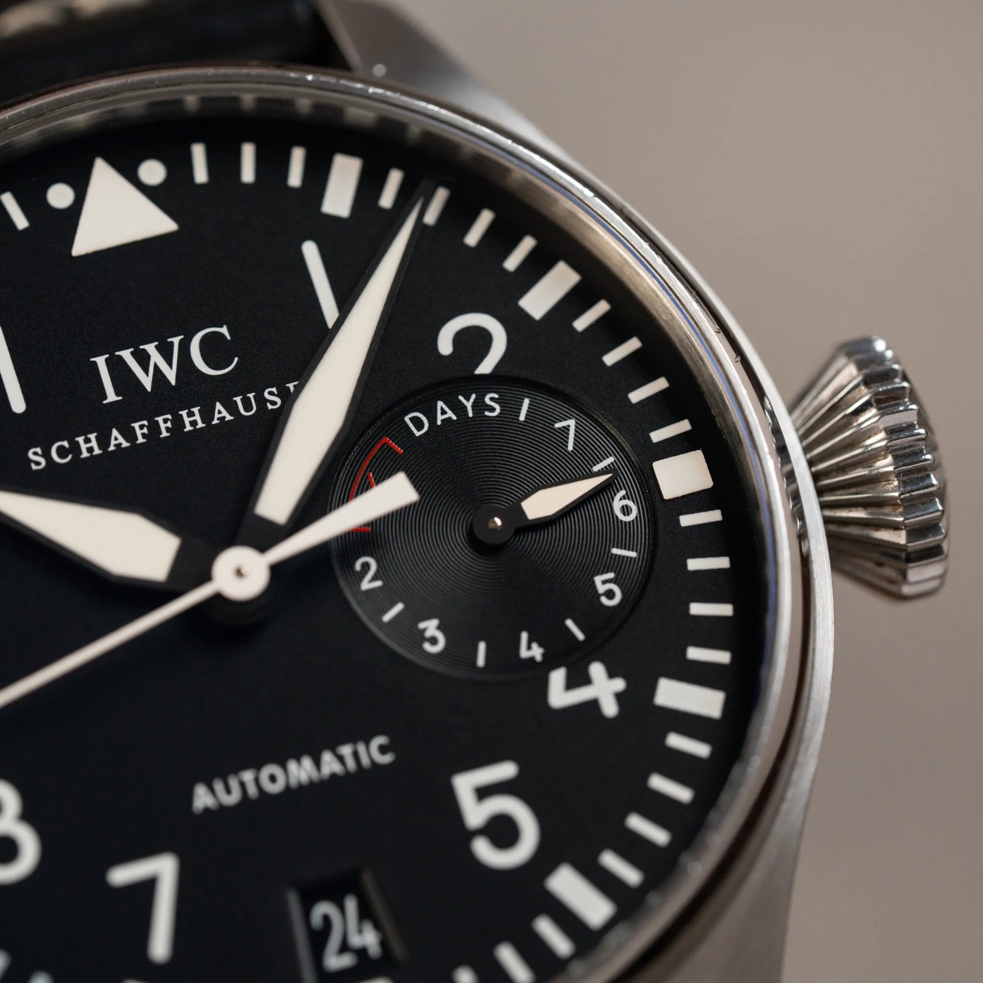Detailaufnahme der IWC Big Pilot 46 Armbanduhr der Referenz IW500401 mit schwarzem Zifferblatt und der Power-Reserve-Anzeige bei 3 Uhr mit Fokus auf der Aufzugskrone und der Gangreserveanzeige