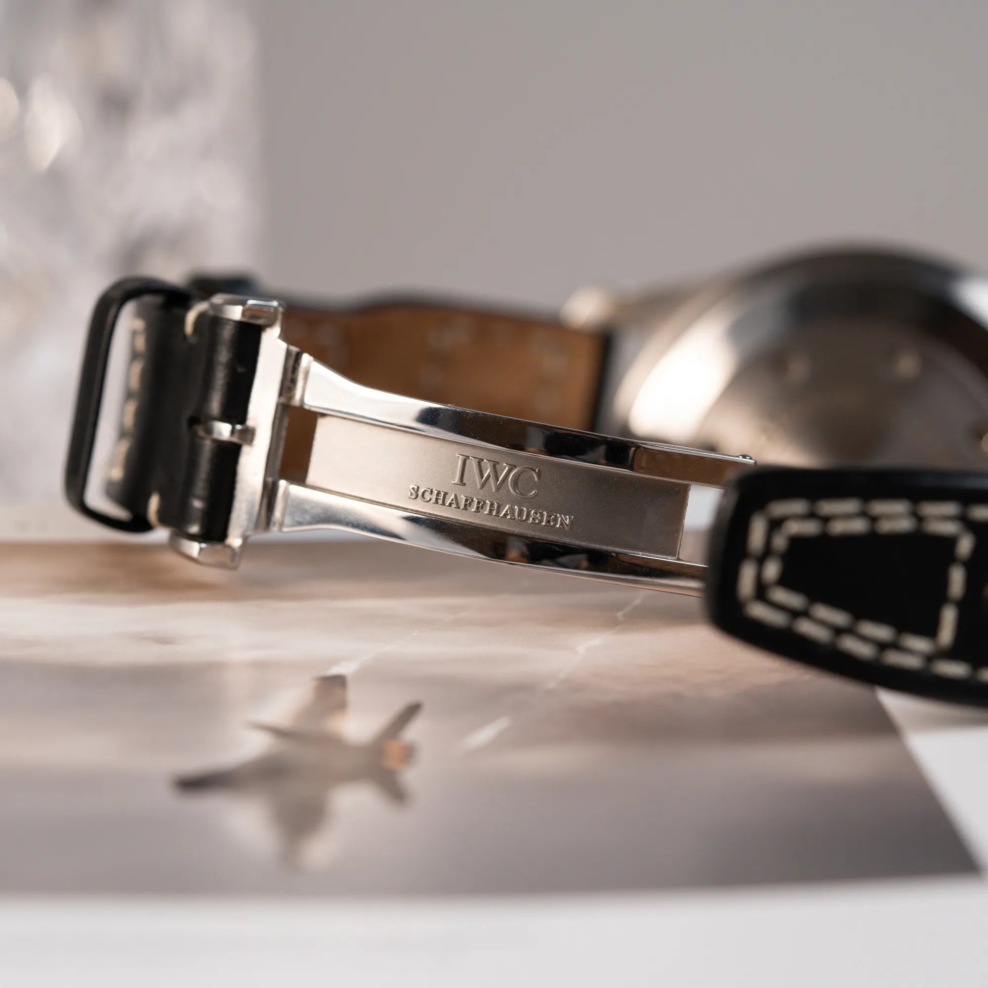 Detailaufnahme des "IWC Schaffhausen" Logos im Inneren der Faltschliesse von der IWC Big Pilot 46 Armbanduhr der Referenz IW500401 mit schwarzem Zifferblatt und der Power-Reserve-Anzeige bei 3 Uhr