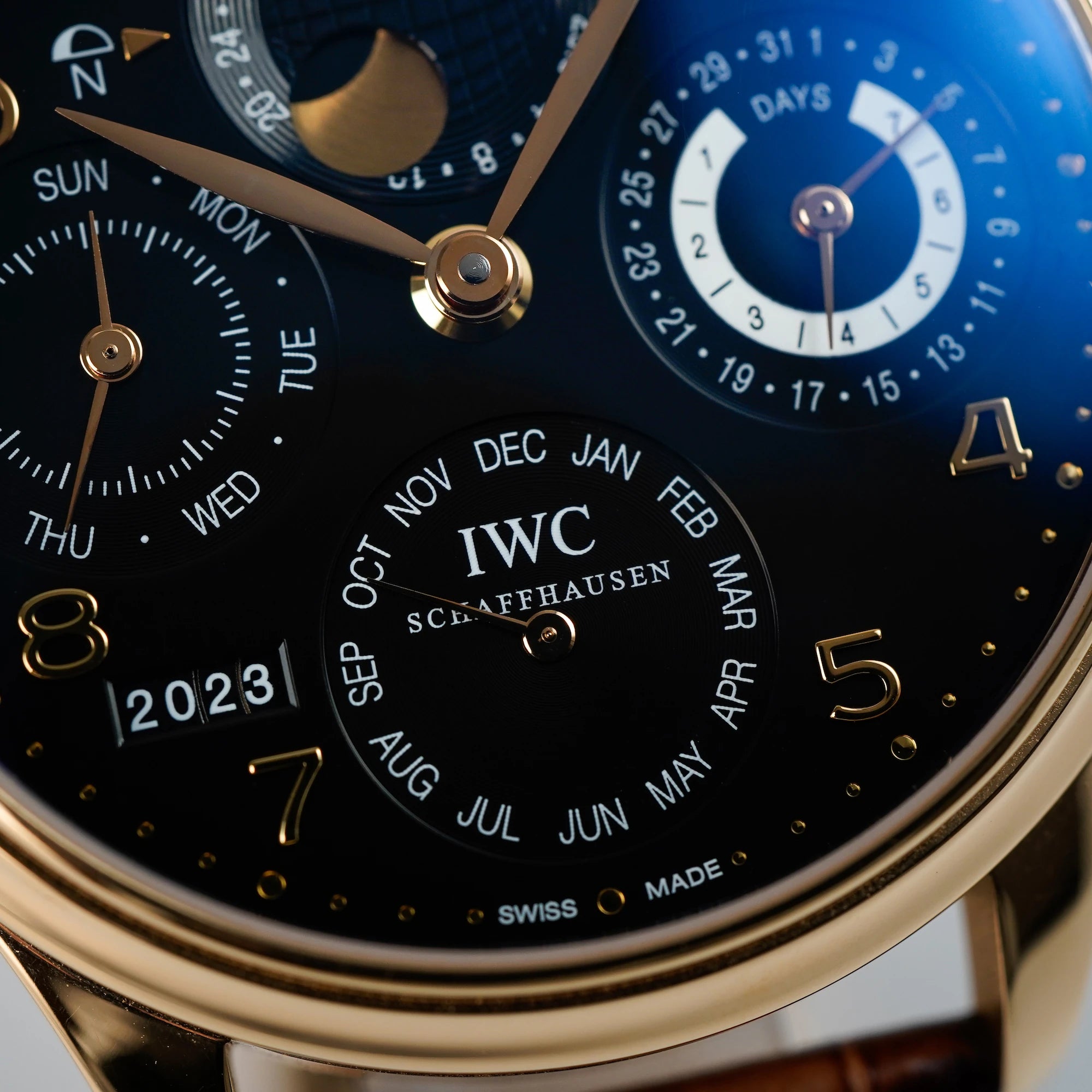 Makroaufnahme des schwarzen Zifferblatts mit Fokus auf die Subdials des Ewigen Kalenders IW502119 in Rotgold von IWC Schaffhausen mit goldenen Indizes