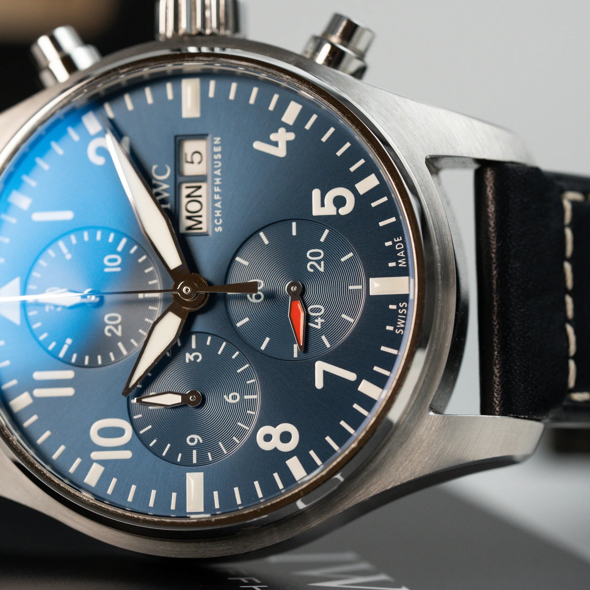 Detailaufnahme des blauen Zifferblatts der IWC Schaffhausen Pilot Fliegeruhr Chronograph 41 mit der Referenz IW388101, während die Uhr auf einem Buch liegt