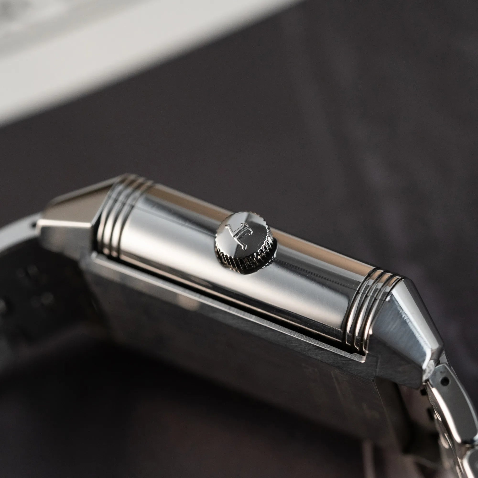 Produktfotografie der Jaeger LeCoultre Grand Reverso 8 am Stahlband mit Blick auf die Aufzugskrone
