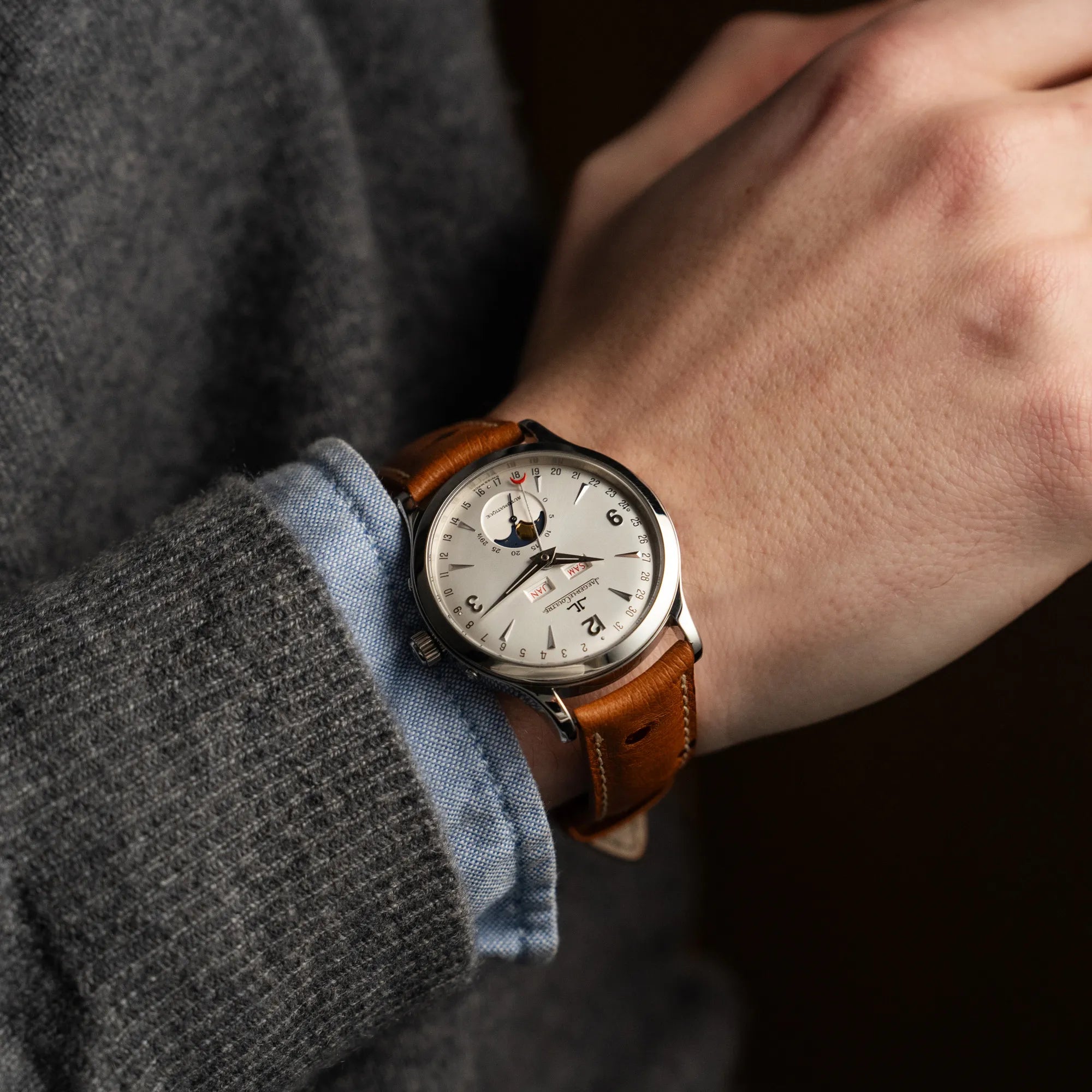 Mann trägt die Jaeger LeCoultre Master Control Calender Moonphase mit silbernem Zifferblatt an einem braunen JLC-Lederband an seinem Handgelenk