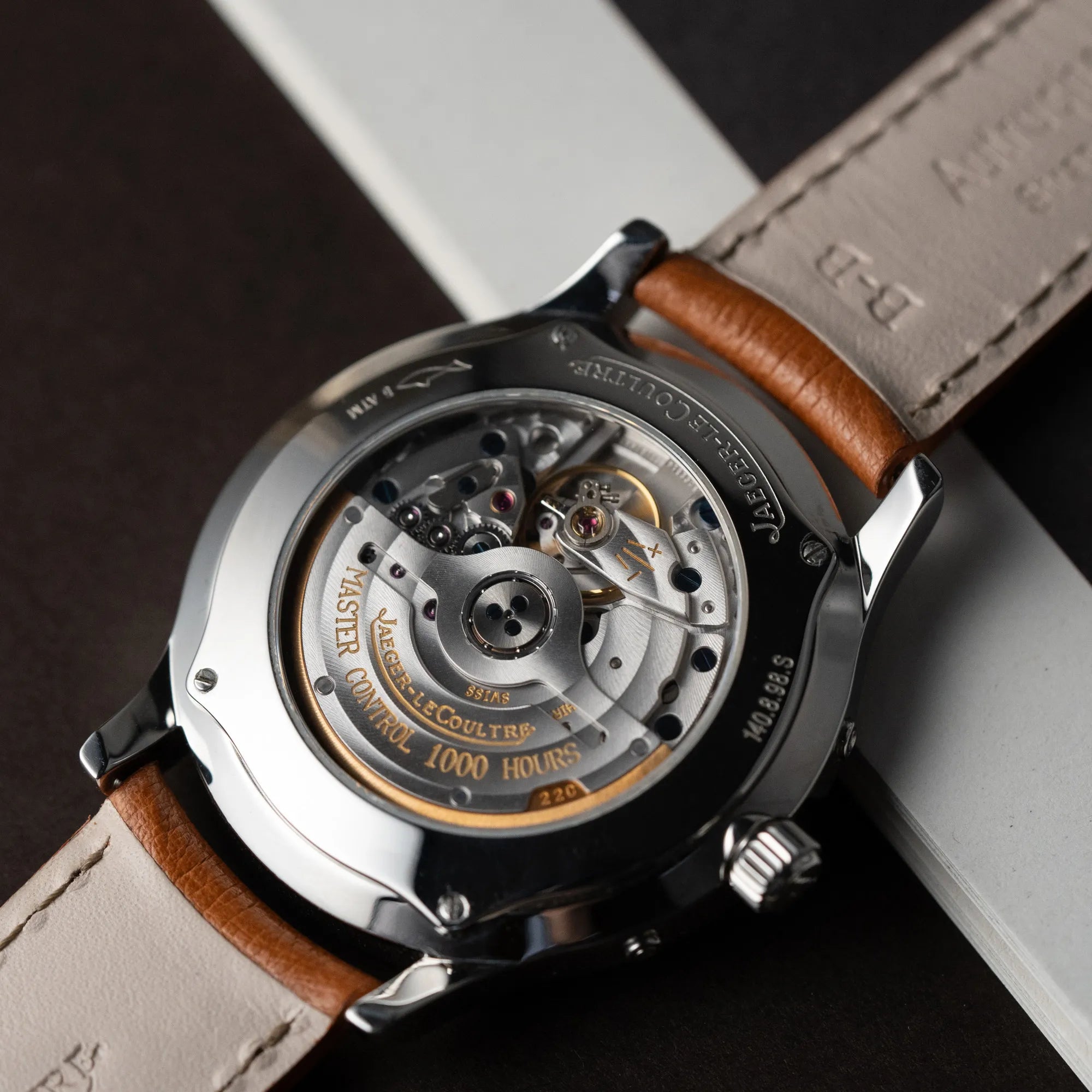 Detailaufnahme des Glasbodens der Jaeger LeCoultre Master Control Calender Moonphase mit silbernem Zifferblatt an einem braunen JLC-Lederband mit Blick auf das automatische Caliber 891