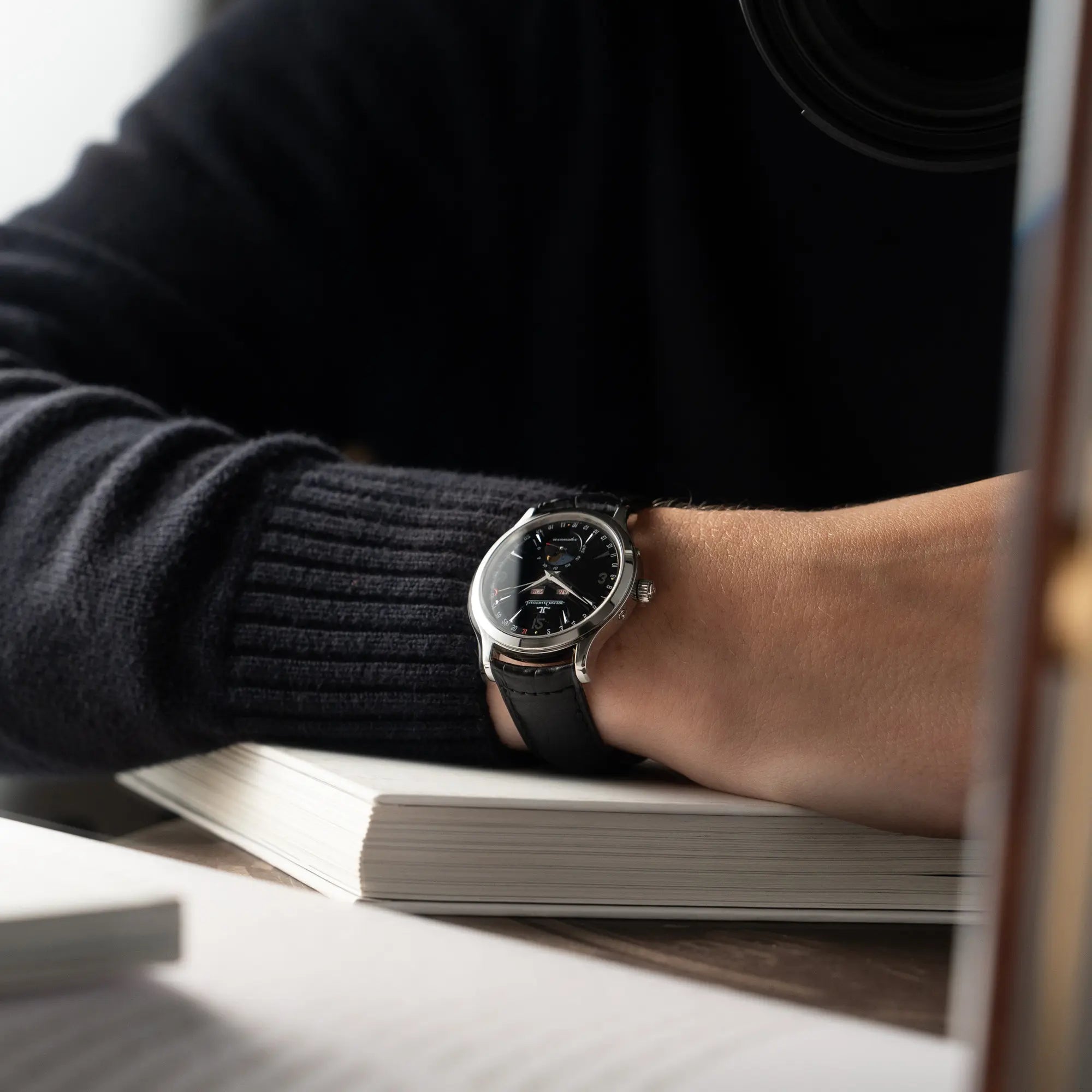 Mann trägt die Jaeger-LeCoultre Master Control Moonphase Calendar mit schwarzem Zifferblatt am schwarzen Lederband am Handgelenk
