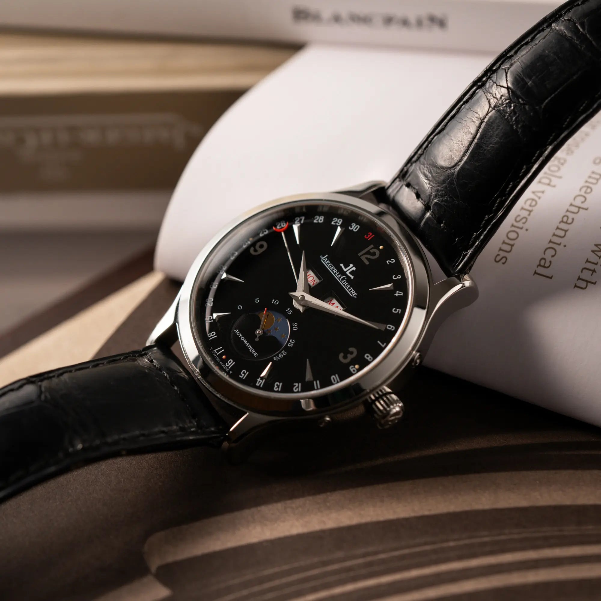 Produktfotografie der Jaeger-LeCoultre Master Control Moonphase Calendar mit schwarzem Zifferblatt am schwarzen Lederband