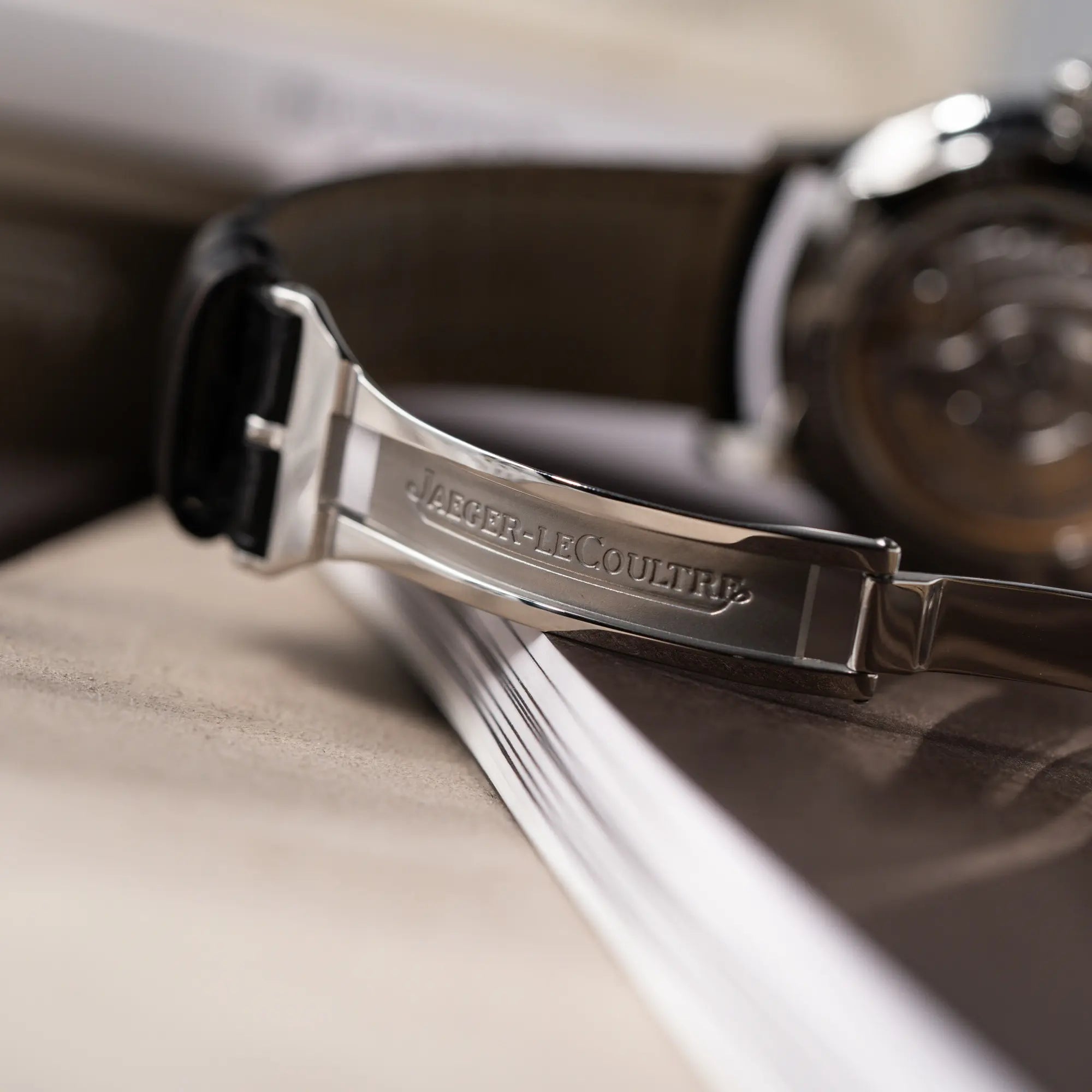 Detailaufnahme des "Jaeger-LeCoultre" Schriftzugs im Inneren der Faltschliesse von der Jaeger-LeCoultre Master Control Moonphase Calendar mit schwarzem Zifferblatt am schwarzen Lederband