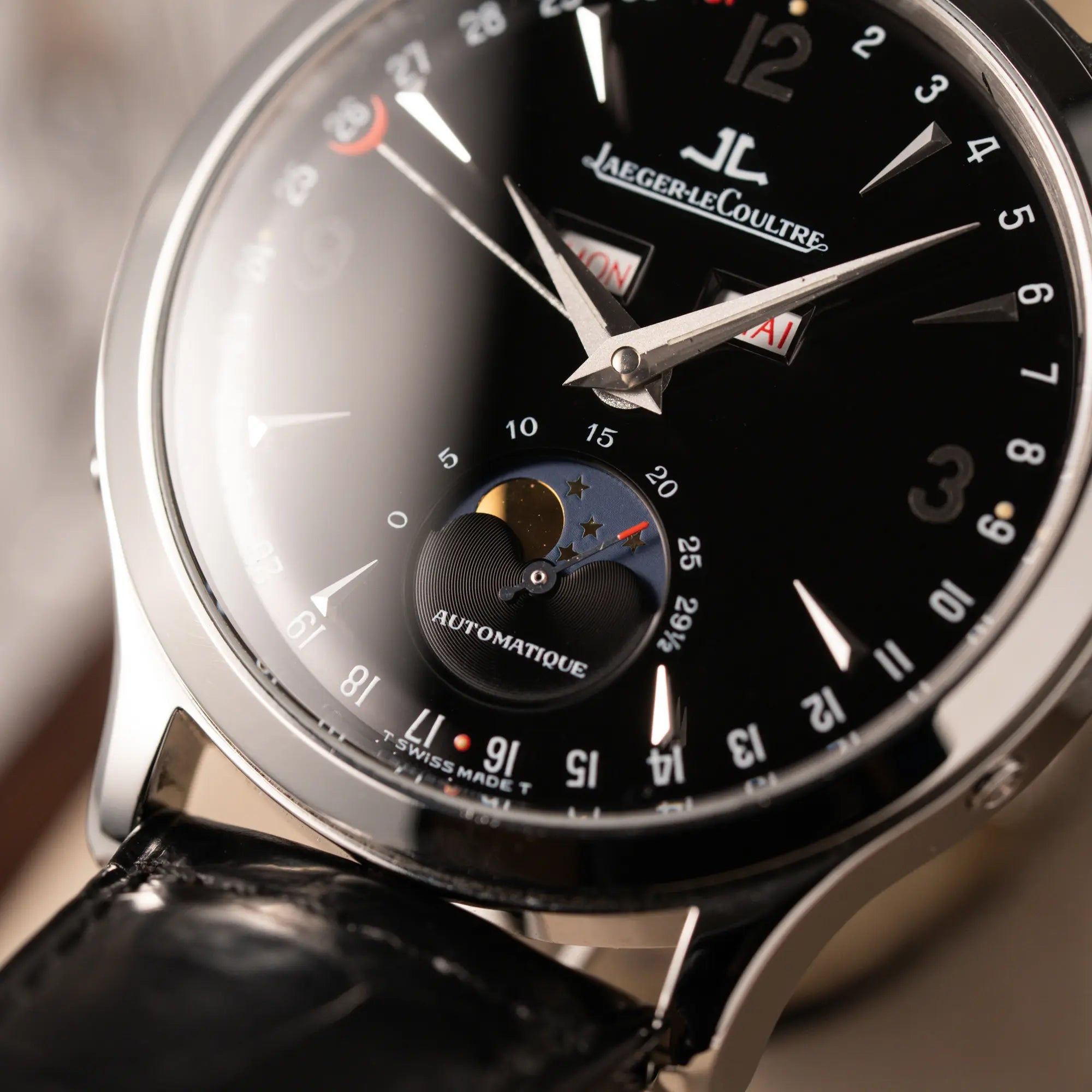 Makroaufnahme der Jaeger-LeCoultre Master Control Moonphase Calendar mit schwarzem Zifferblatt am schwarzen Lederband