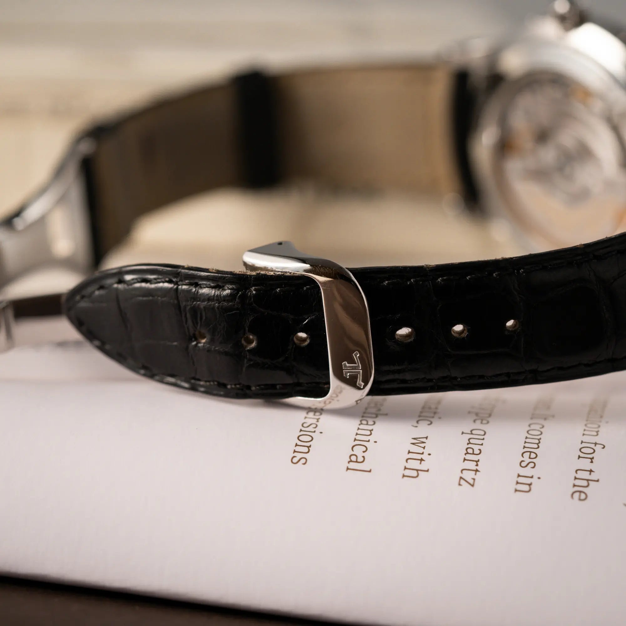 Detailaufnahme der originalen Faltschliesse mir JLC-Logo von der der Jaeger-LeCoultre Master Control Moonphase Calendar mit schwarzem Zifferblatt am schwarzen Lederband