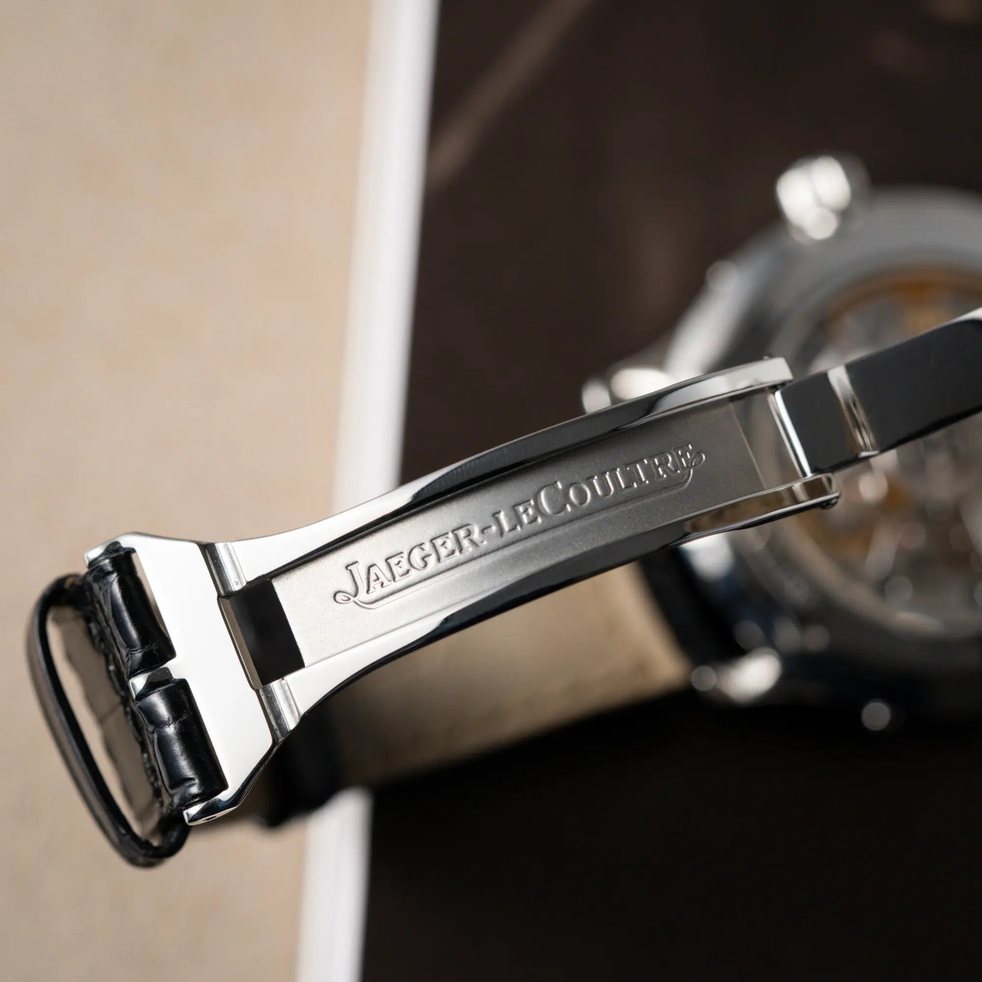 Makroaufnahme der originalen Faltschliesse von der Jaeger-LeCoultre Master Control Moonphase Calendar mit schwarzem Zifferblatt am schwarzen Lederband