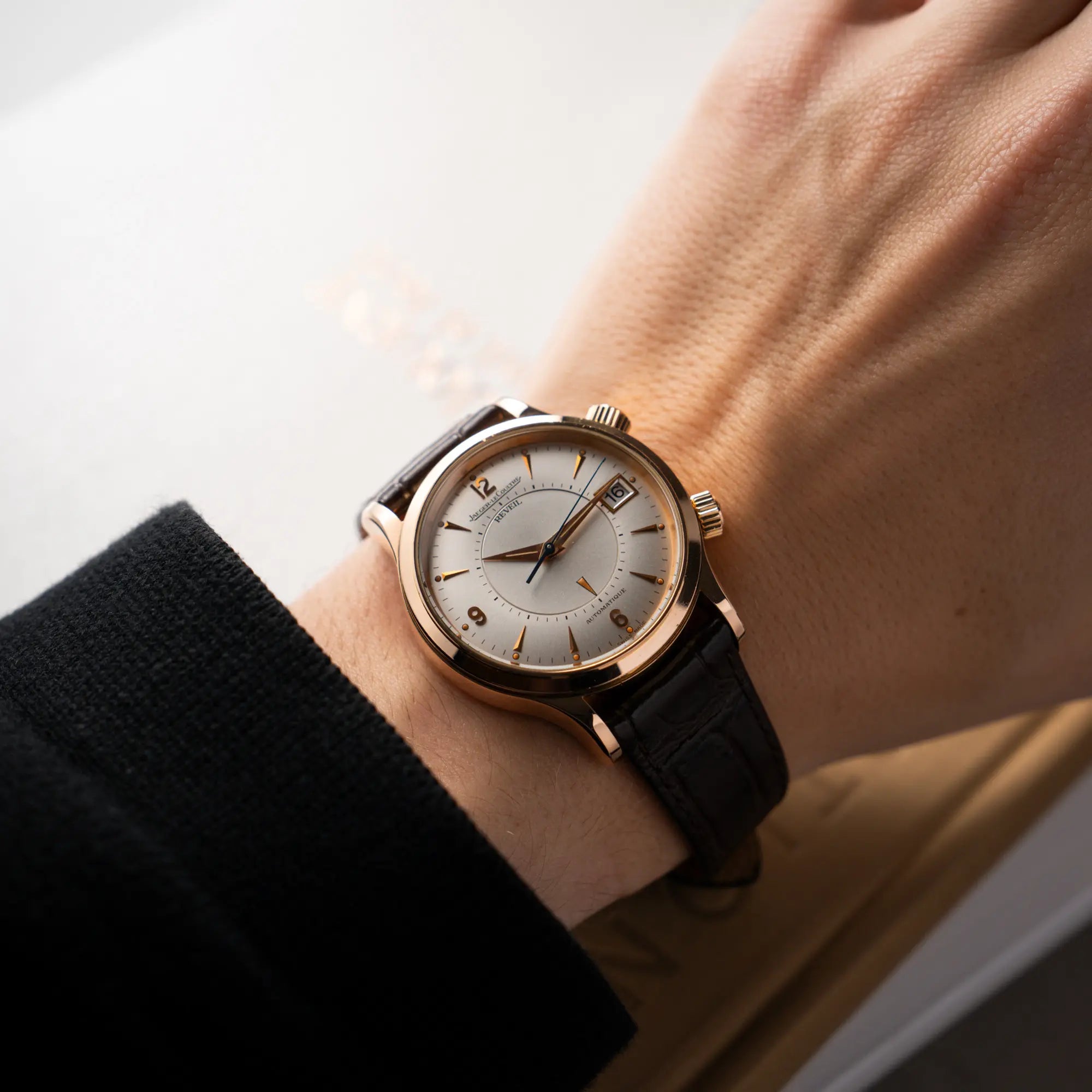 Mann trägt die Jaeger-LeCoultre Master Memovox 141.2.97 Armbanduhr in Rosegold mit braunem Lederband am Handgelenk