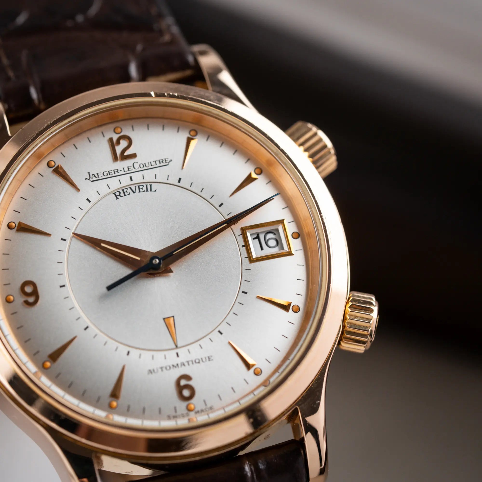Produktfotografie der Jaeger-LeCoultre Master Memovox 141.2.97 Armbanduhr in Rosegold mit braunem Lederband zeigt die Lünette und das weiß-silberne Zifferblatt