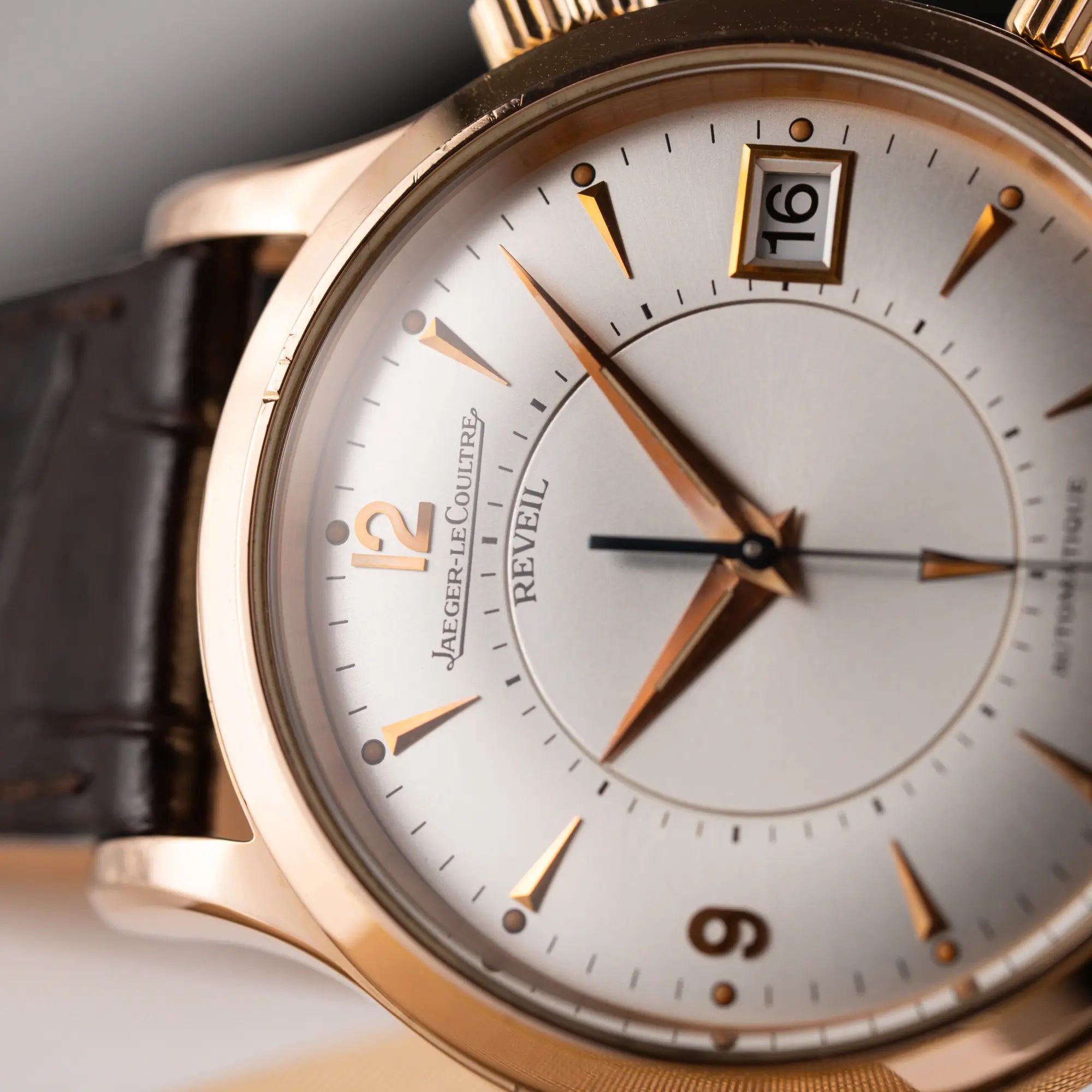 Detailaufnahme der seitlich auf dem Gehäuse liegenden Jaeger-LeCoultre Master Memovox 141.2.97 Armbanduhr in Rosegold mit braunem Lederband