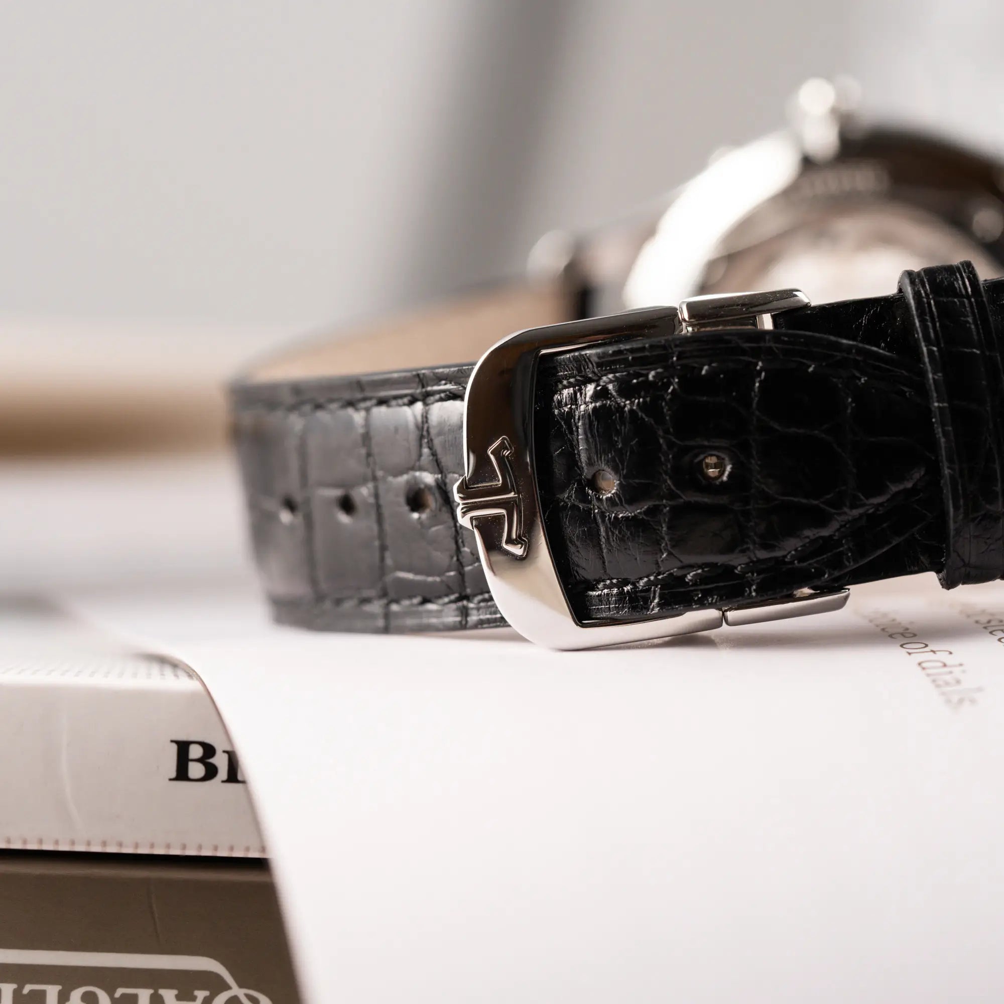 Makroaufnahme der Doppel-Faltschliesse am schwarzen Lederband mit JLC-Logo von der Jaeger-LeCoultre Master Ultra Thin mit Mondphase der Referenz 176.8.64.S mit weiß-silbernem Zifferblatt