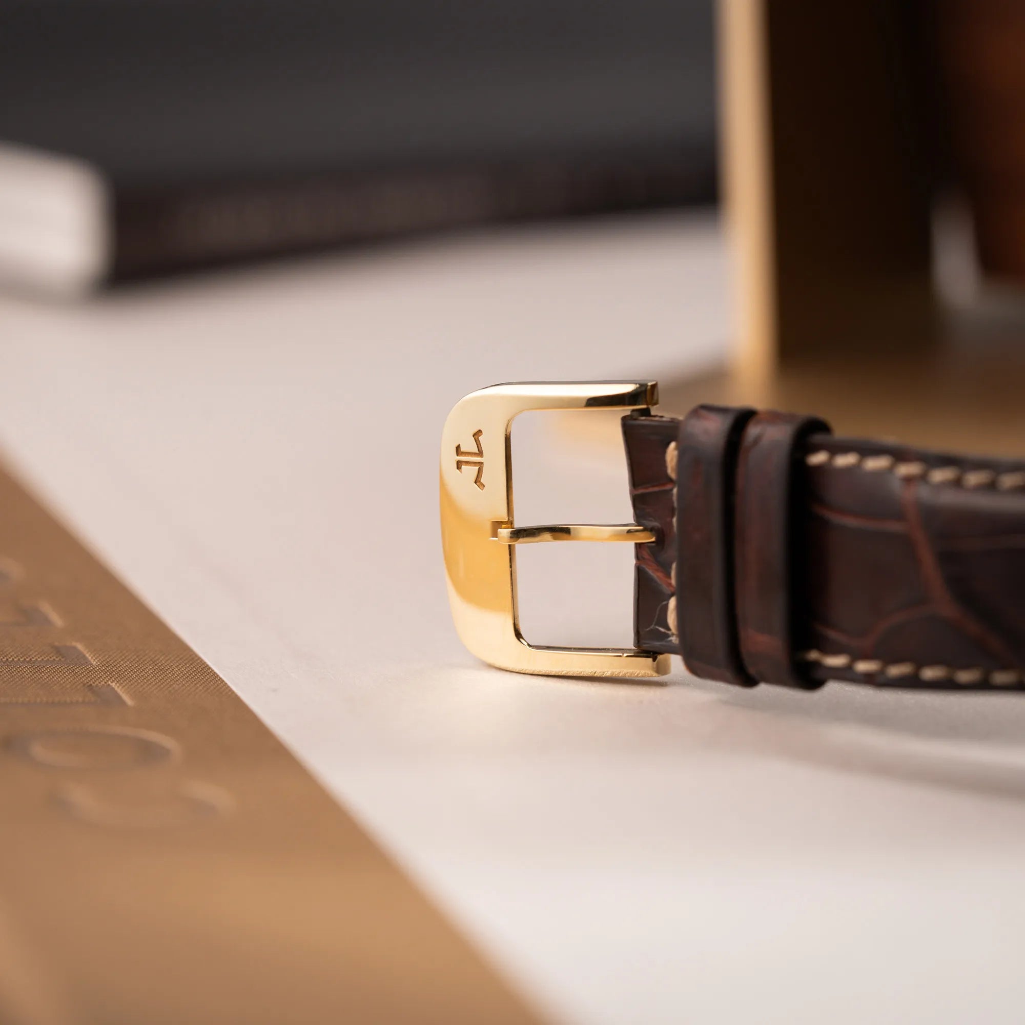 Detailaufnahme der goldenen Dornschliesse derr Jaeger-LeCoultre Reverso Grande Date der Referenz 240.1.15 mit einem Gelbgold-Gehäuse am braunen Lederband