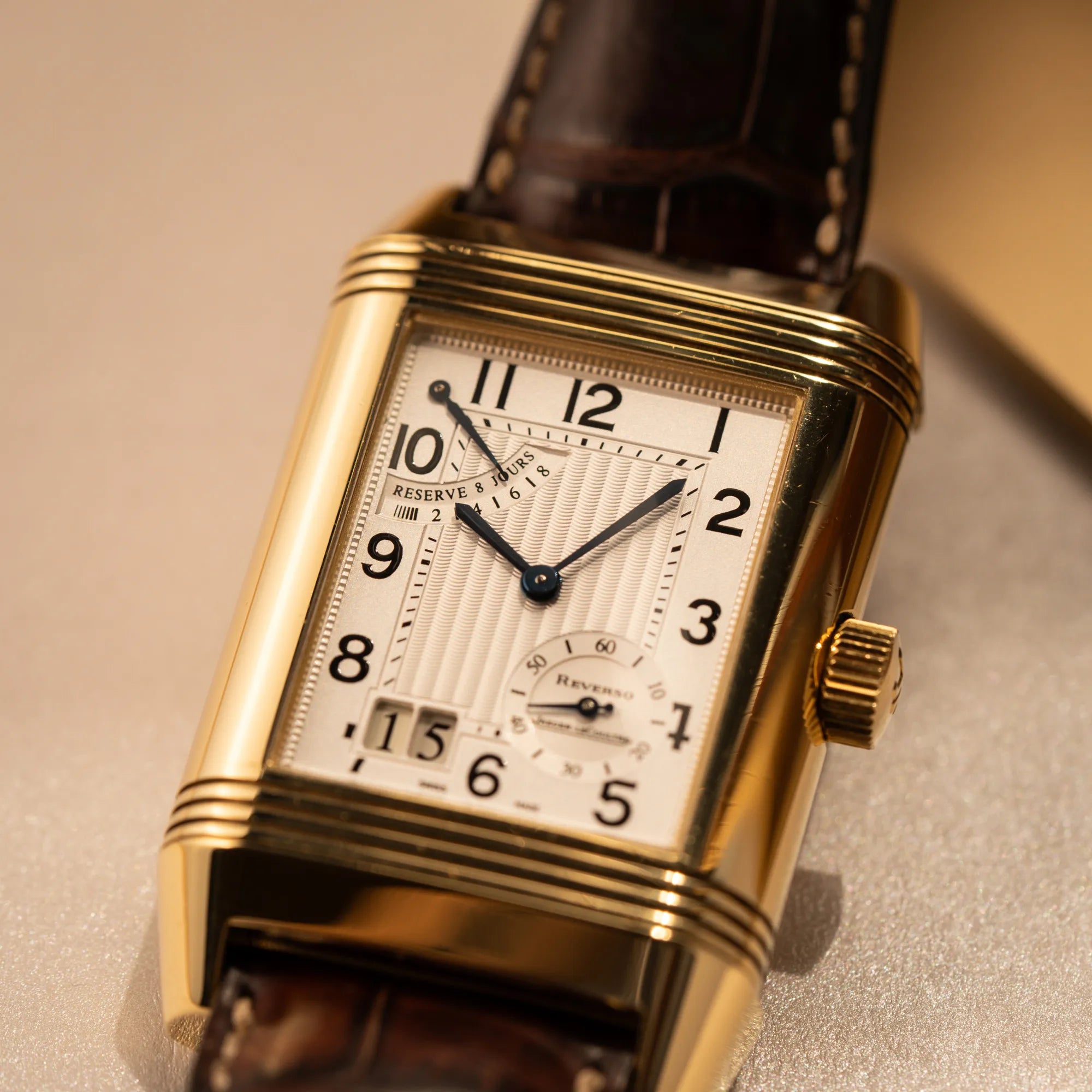 Detailaufnahme der Jaeger-LeCoultre Reverso Grande Date der Referenz 240.1.15 mit einem Gelbgold-Gehäuse am braunen Lederband
