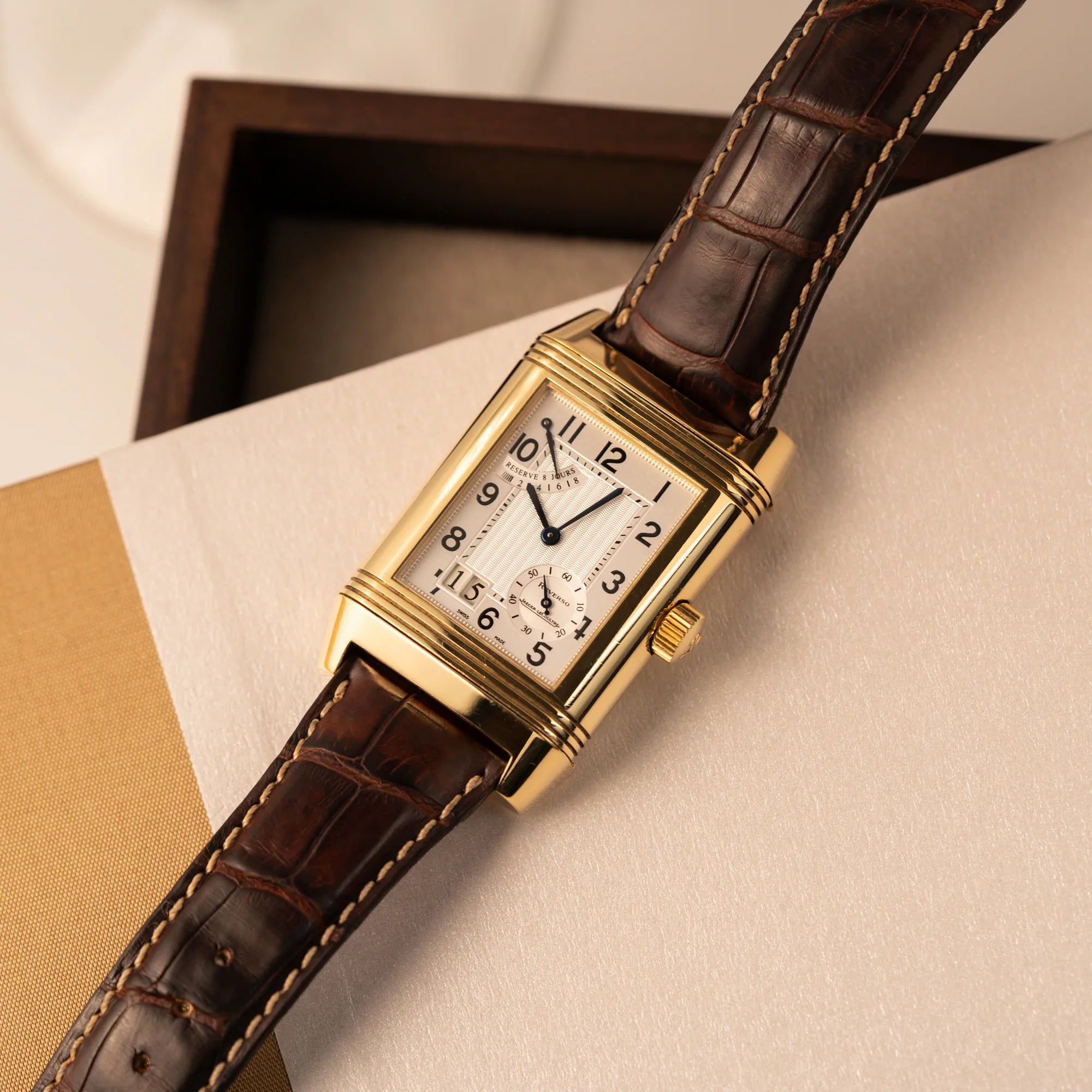 Produktfotografie der Jaeger-LeCoultre Reverso Grande Date der Referenz 240.1.15 mit einem Gelbgold-Gehäuse am braunen Lederband