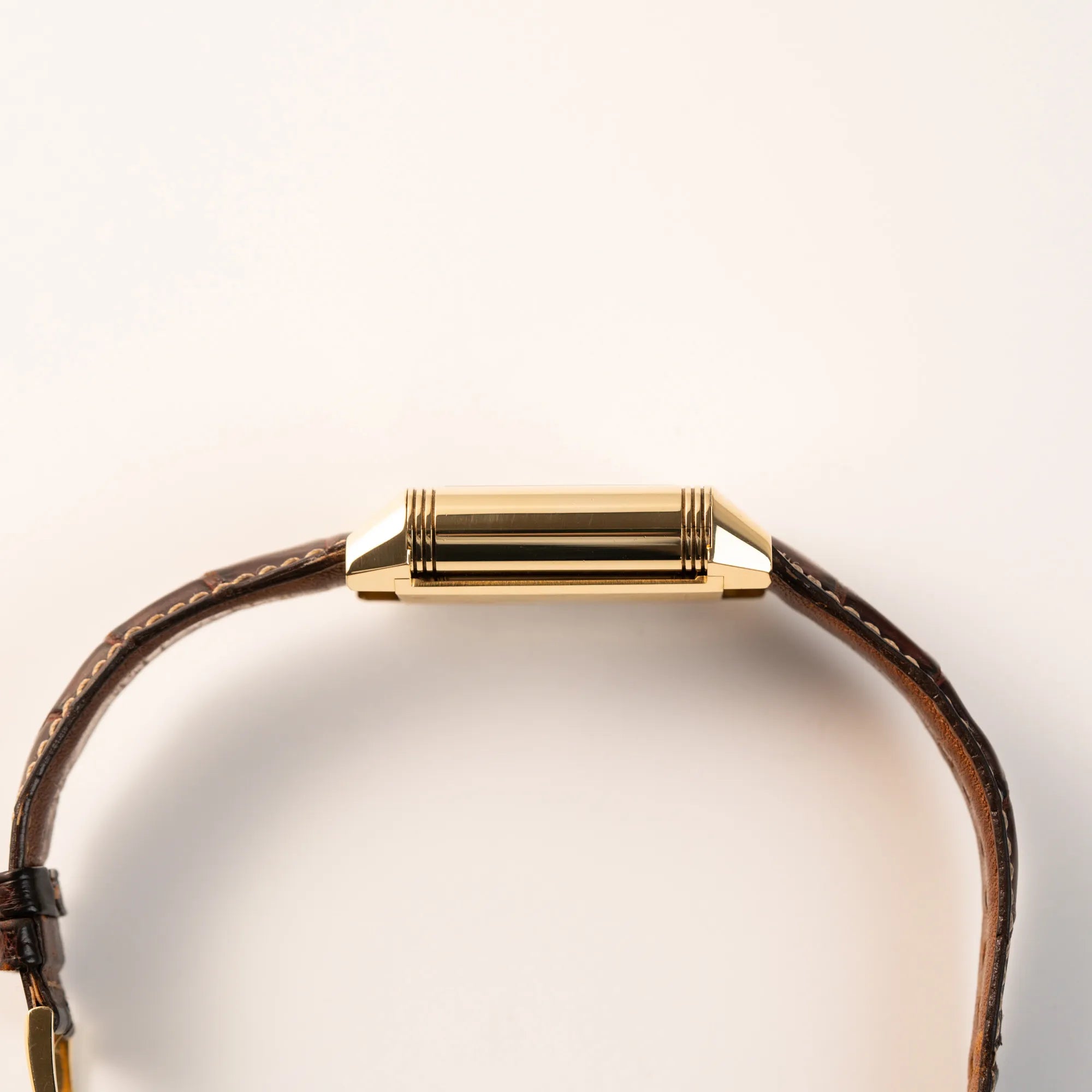Seitliches Gehäuse der Jaeger-LeCoultre Reverso Grande Date der Referenz 240.1.15 mit einem Gelbgold-Gehäuse am braunen Lederband