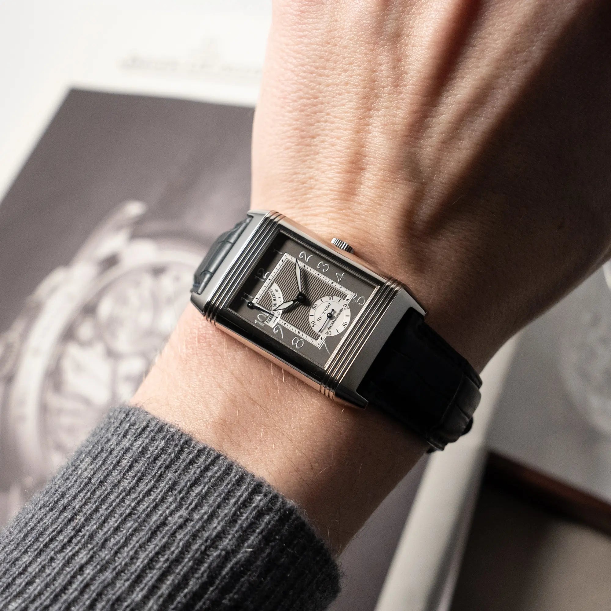 Mann trägt die Jaeger LeCoultre Reverso "Reserve de Marche" mit Platingehäuse am Lederband an seinem Handgelenk